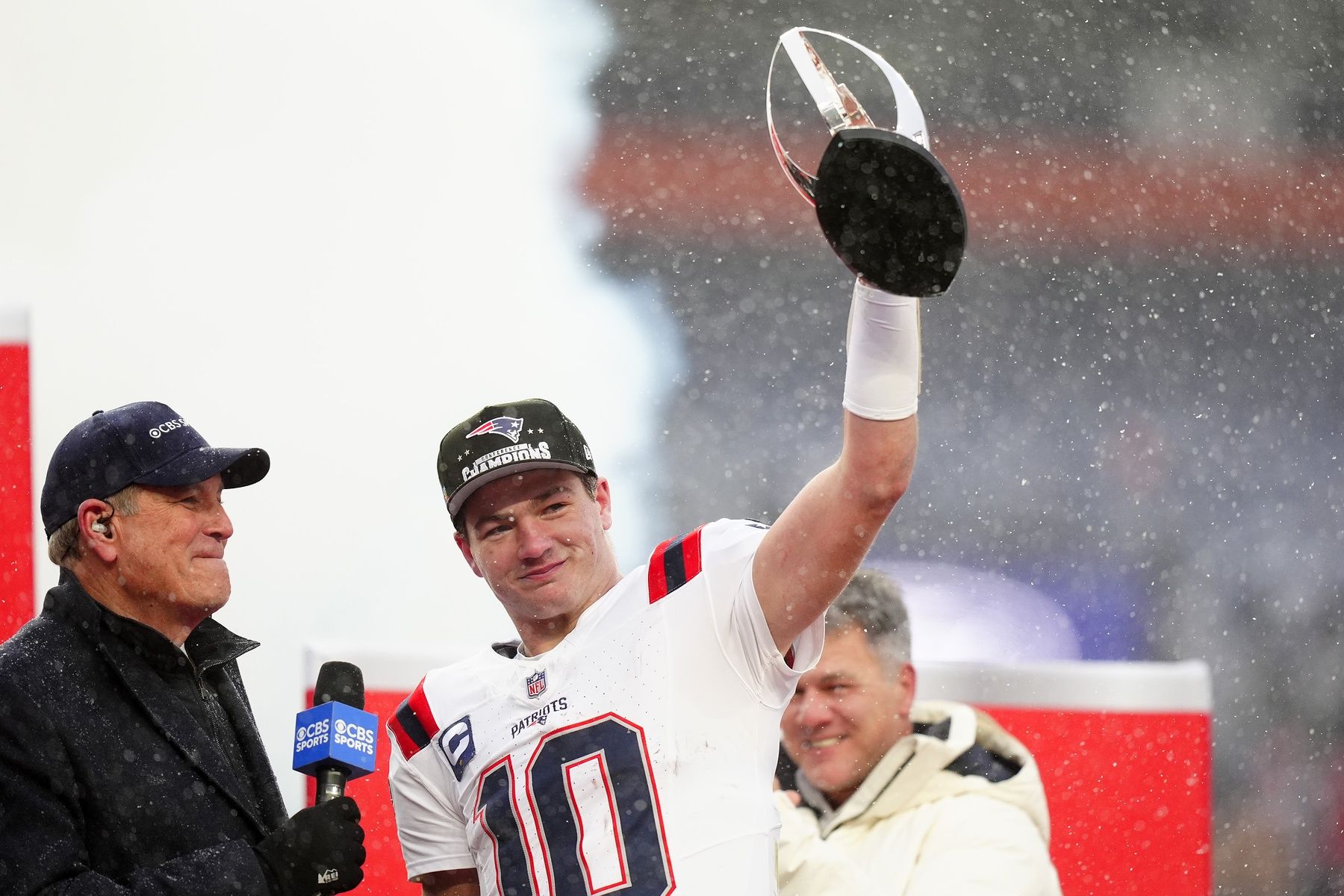 New England Patriots quarterback Drake Maye (10) holds the AFC Championship trophy while speaking to the media after defeating the Denver Broncos in the 2026 AFC Championship Game at Empower Field at Mile High.