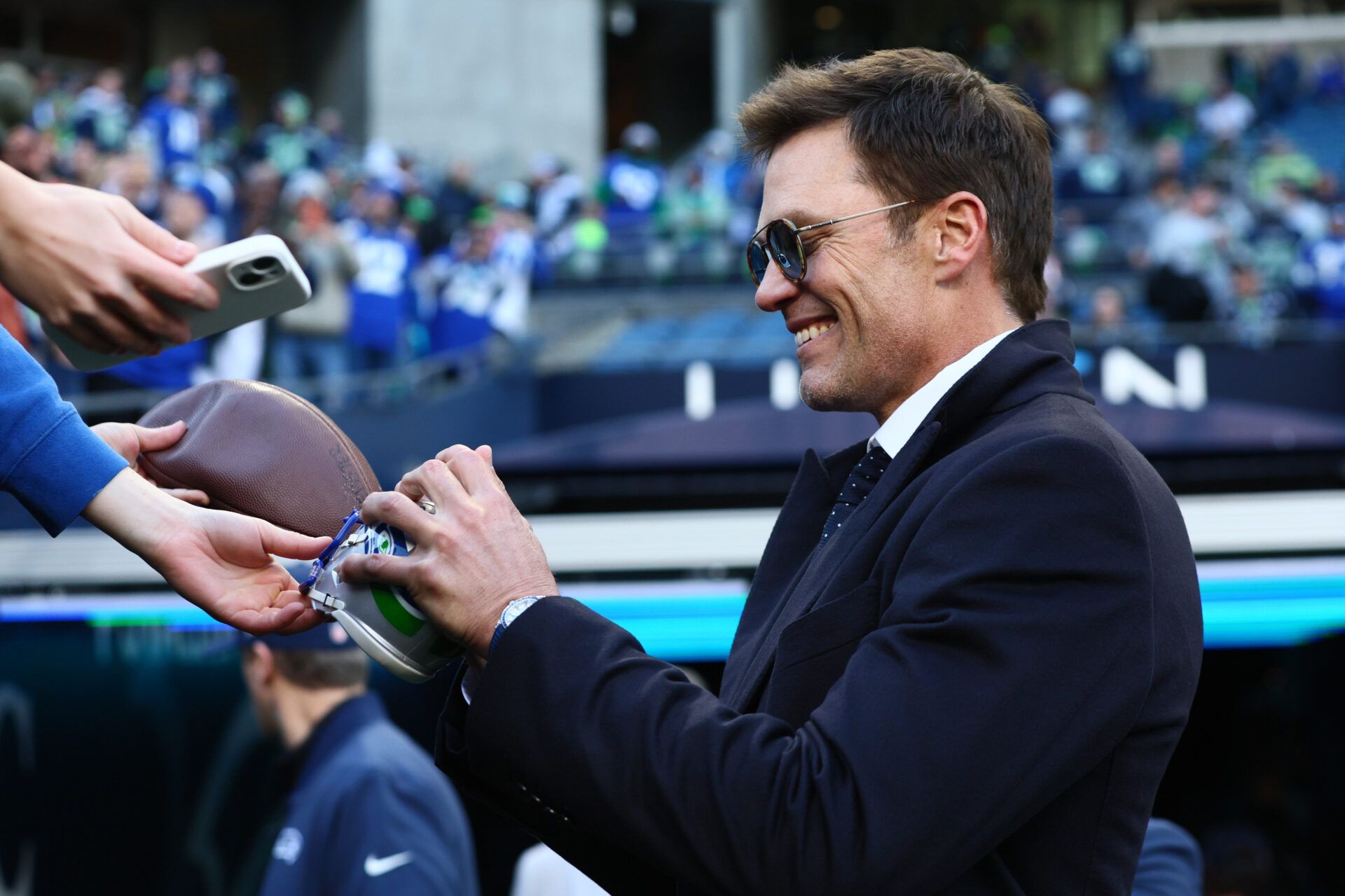 Tom Brady signs autographs before the 2026 NFC Championship Game between the Seattle Seahawks and the Los Angeles Rams at Lumen Field.