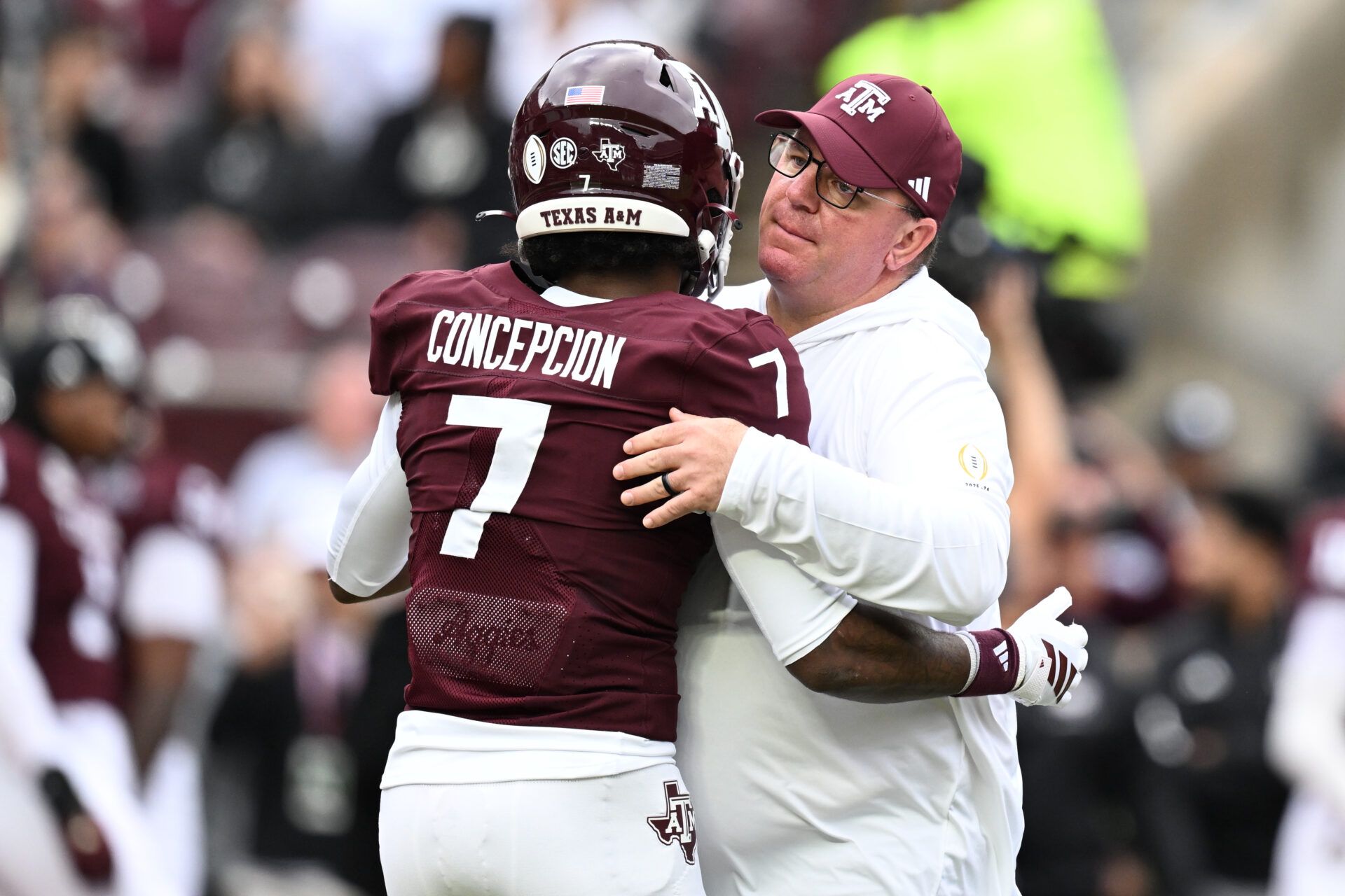 Texas A&M Aggies head coach Mike Elko hugs Texas A&M Aggies wide receiver KC Concepcion (7) prior to the game against the Miami Hurricanes during the first round of the CFP National Playoff at Kyle Field.