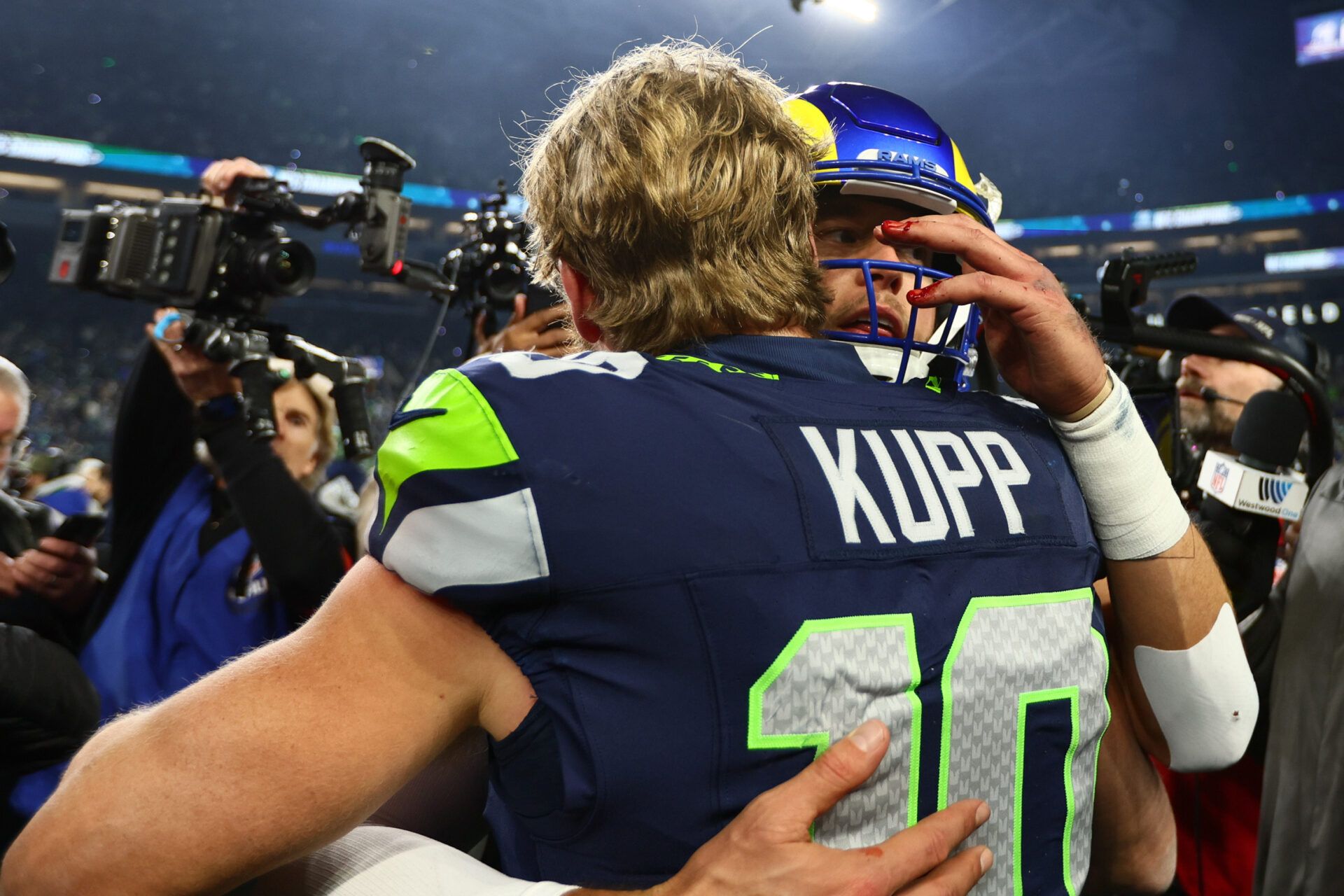 Seattle Seahawks wide receiver Cooper Kupp (10) embraces Los Angeles Rams quarterback Matthew Stafford (9) after the 2026 NFC Championship Game at Lumen Field.