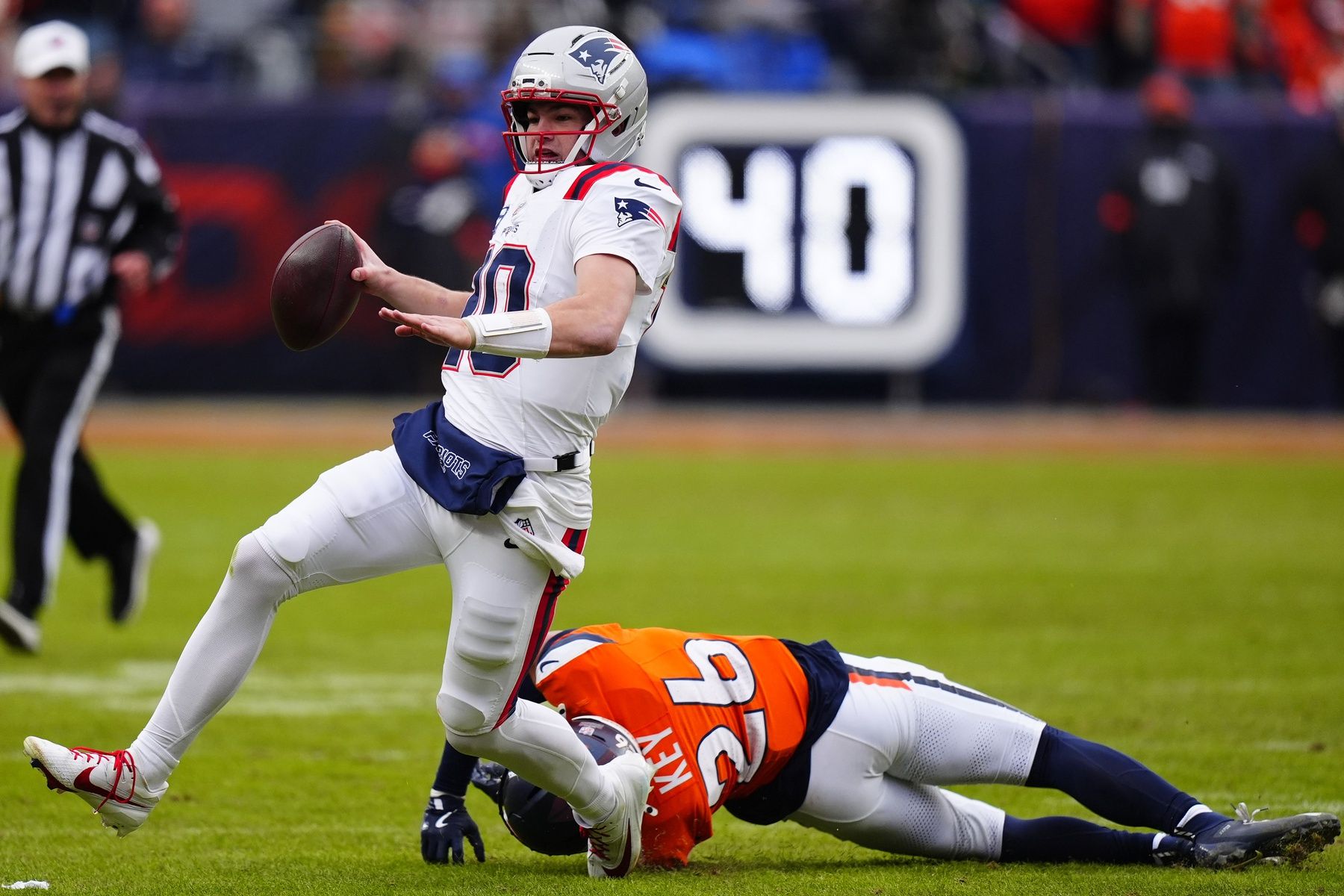 New England Patriots quarterback Drake Maye (10) rushes the ball against Denver Broncos safety Devon Key (26) during the first half in the 2026 AFC Championship Game at Empower Field at Mile High.