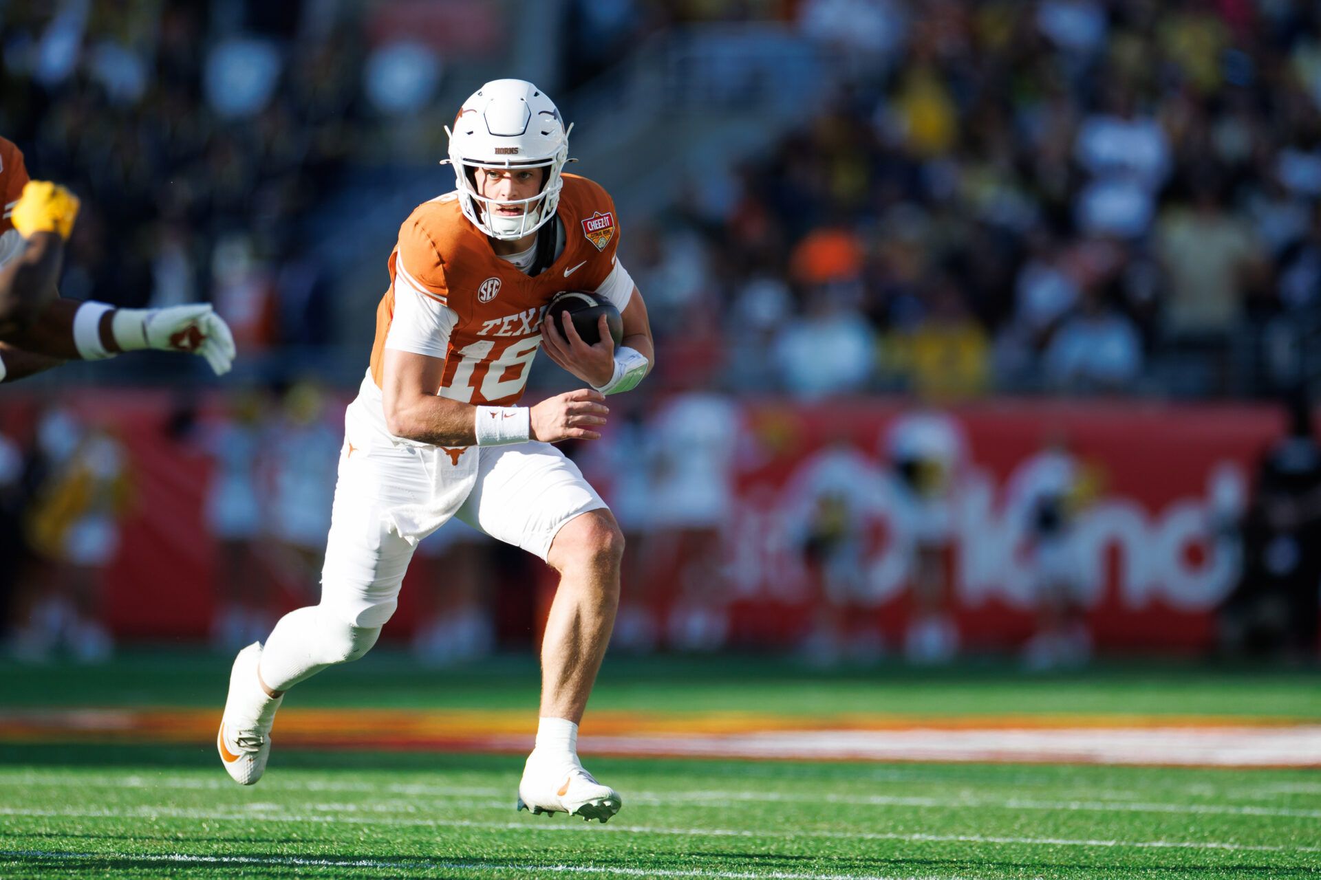 Texas Longhorns quarterback Arch Manning (16) runs with the ball against the Michigan Wolverines during the first half at Camping World Stadium.