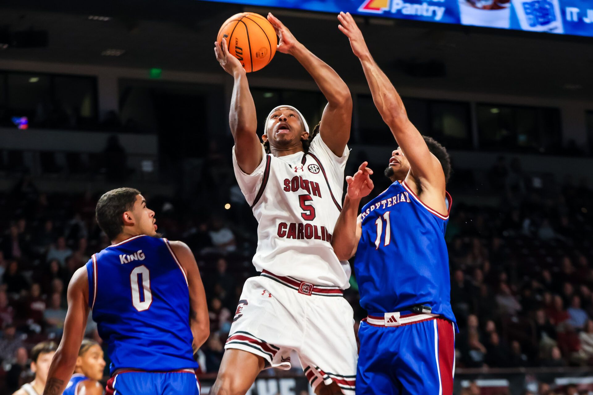 South Carolina Gamecocks guard Meechie Johnson (5) drives between Presbyterian Blue Hose guard Iverson King (0) and Presbyterian Blue Hose guard Erik Taylor (11) in the first half at Colonial Life Arena.