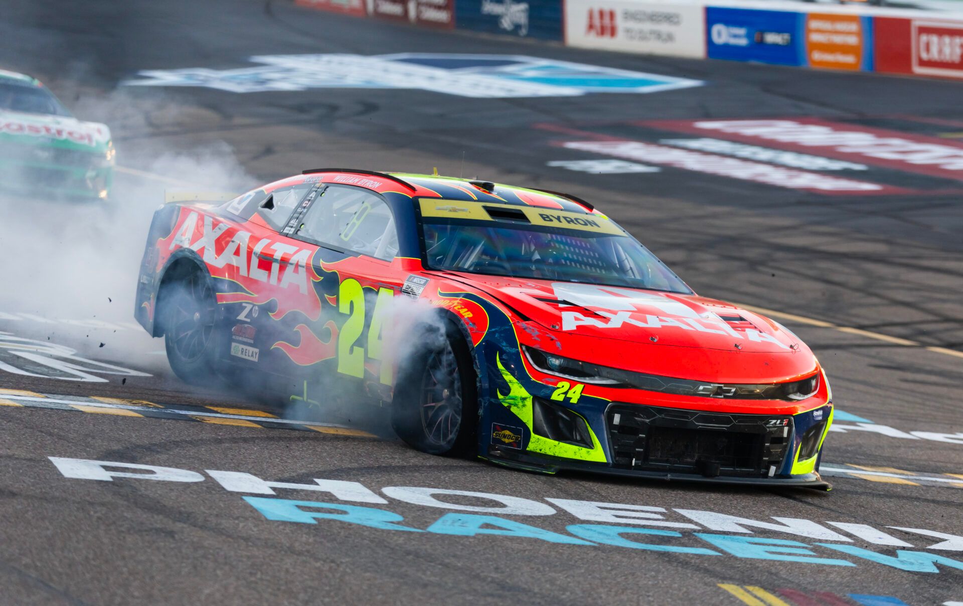 Smoke comes from the car of NASCAR Cup Series driver William Byron (24) after hitting the wall with a tire failure in the closing laps of the NASCAR Championship race at Phoenix Raceway.