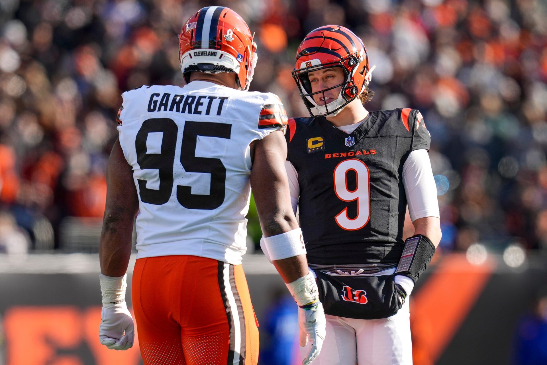 Cincinnati Bengals quarterback Joe Burrow (9) and Cleveland Browns defensive end Myles Garrett (95) talk between plays in the first quarter of the NFL Week 18 game between the Cincinnati Bengals and the Cleveland Browns at Paycor Stadium in Downtown Cincinnati on Sunday, Jan. 4, 2026.