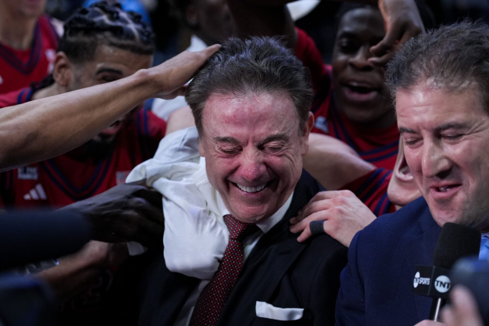 St. John's Red Storm head coach Rick Pitino is mobbed by his team after defeating the Xavier Musketeers at the Cintas Center. The win is the 900th of Pitino’s career.