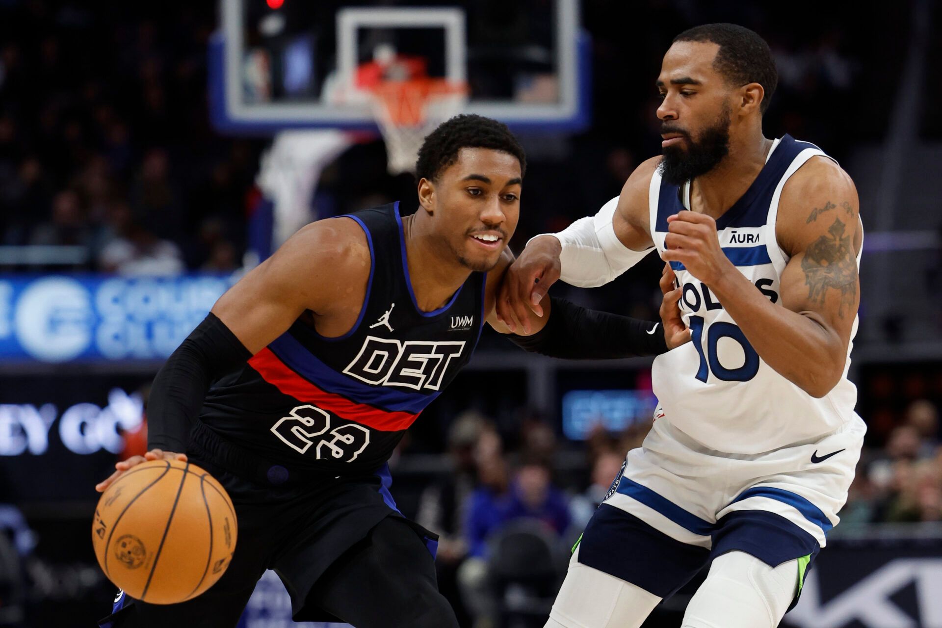 Detroit Pistons guard Jaden Ivey (23) dribbles defended by Minnesota Timberwolves guard Mike Conley (10) in the second half at Little Caesars Arena.
