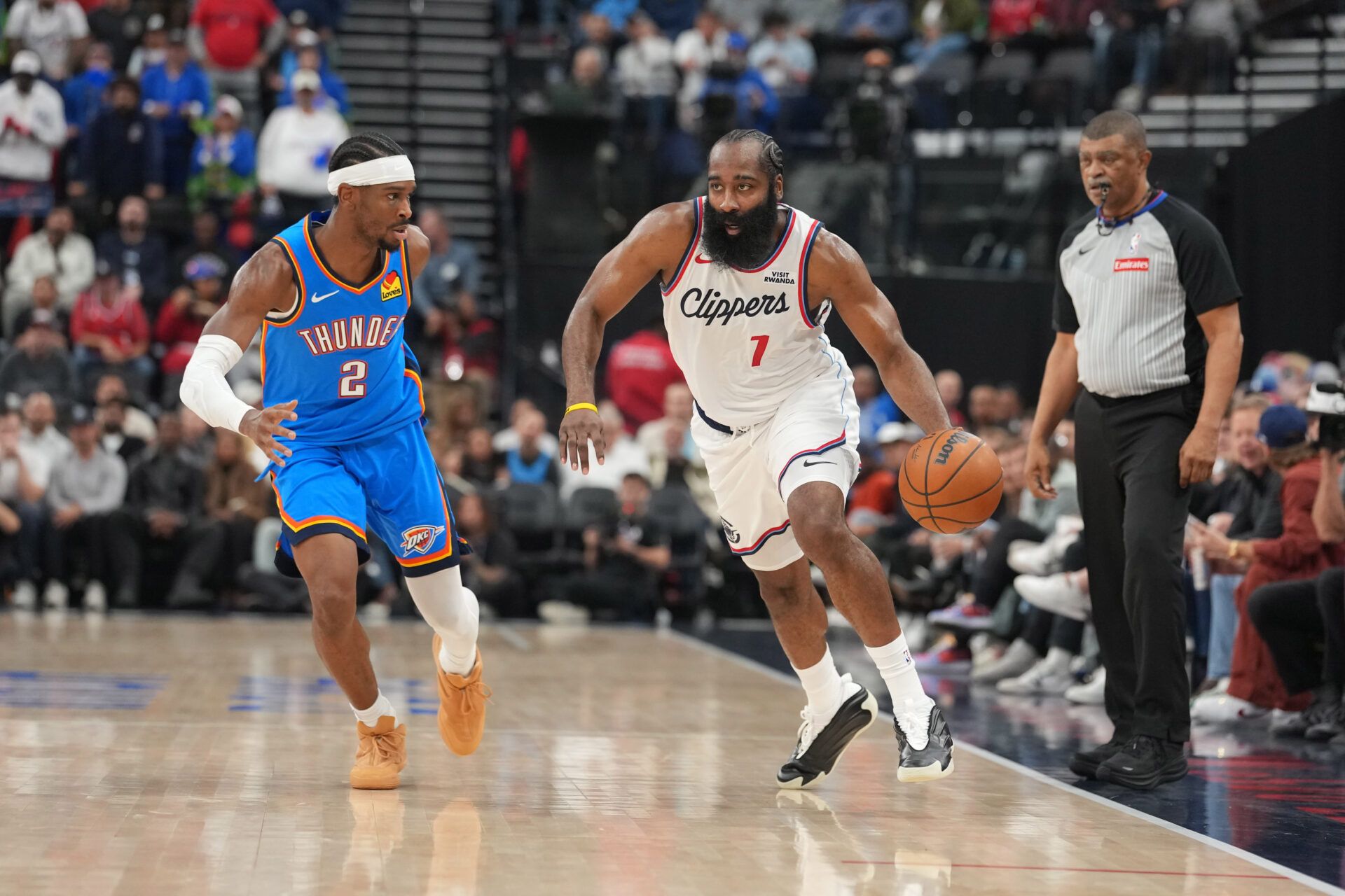 LA Clippers guard James Harden (1) dribbles the ball against Oklahoma City Thunder guard Shai Gilgeous-Alexander (2) in the first half at Intuit Dome.