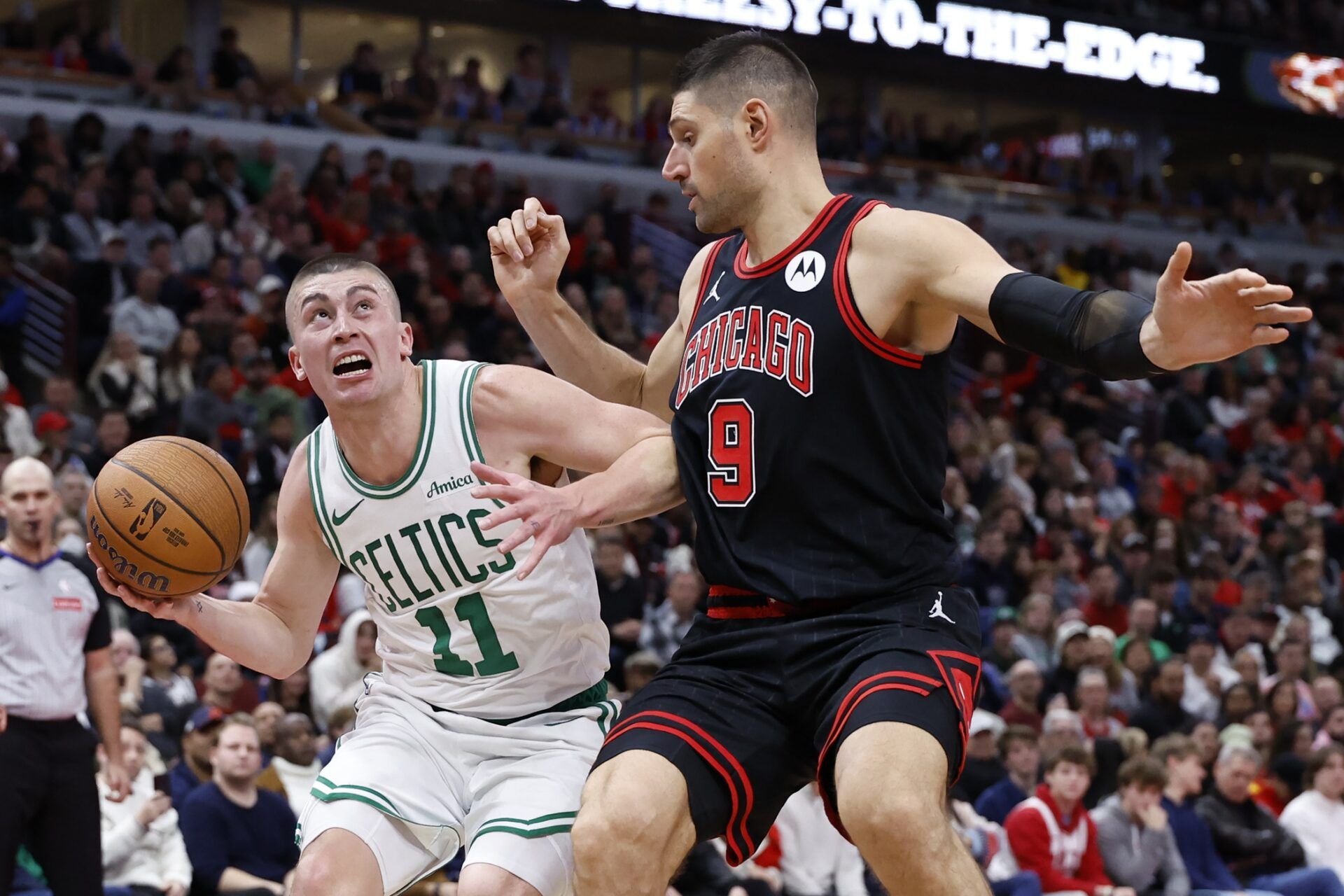 Boston Celtics guard Payton Pritchard (11) drives to the basket against Chicago Bulls center Nikola Vucevic (9) during the second half at United Center.