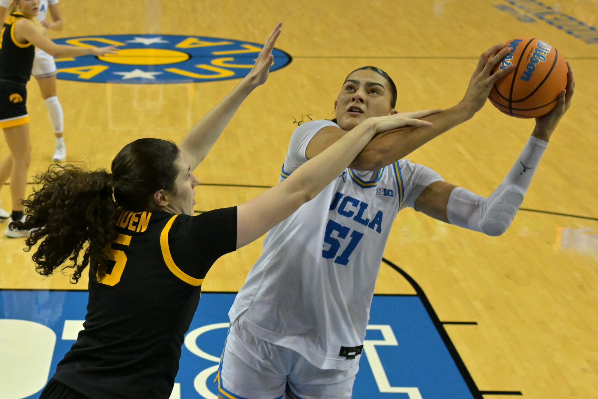 Iowa Hawkeyes guard Ava Heiden (5) defends UCLA Bruins center Lauren Betts (51) as she looks to shoot the ball in the first half at Pauley Pavilion presented by Wescom Financial.