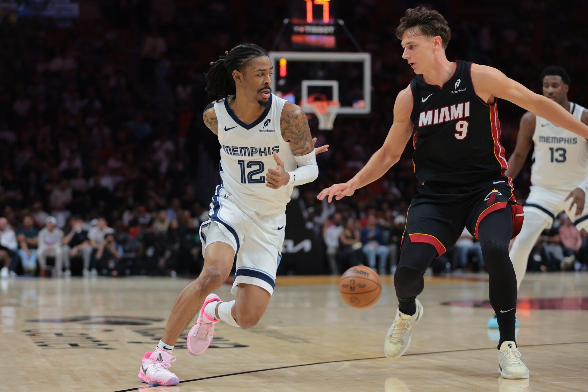 Memphis Grizzlies guard Ja Morant (12) passes the basketball as Miami Heat guard Pelle Larsson (9) defends during the second quarter at Kaseya Center.