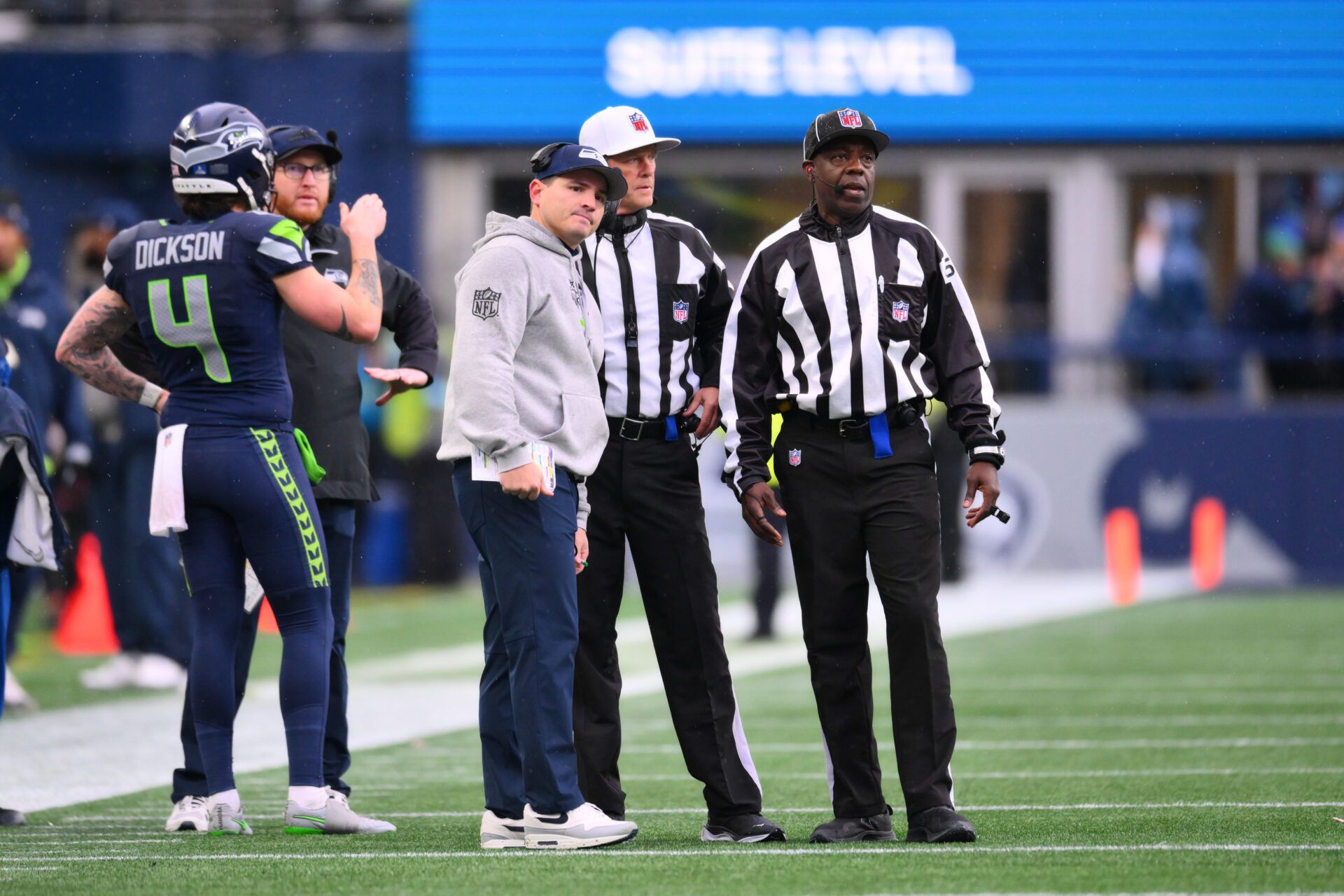 Seattle Seahawk head coach Mike Macdonald stands with referee Craig Wrolstad (4) and side judge Gary Cavaletto (60) during the first half against the Minnesota Vikings at Lumen Field.