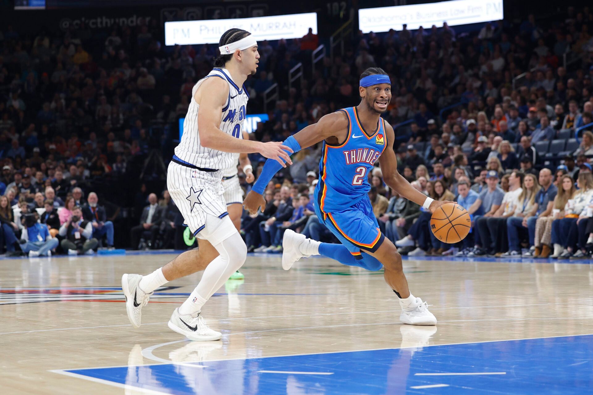Oklahoma City Thunder guard Shai Gilgeous-Alexander (2) drives around Orlando Magic forward Jamal Cain (8) during the second half at Paycom Center.