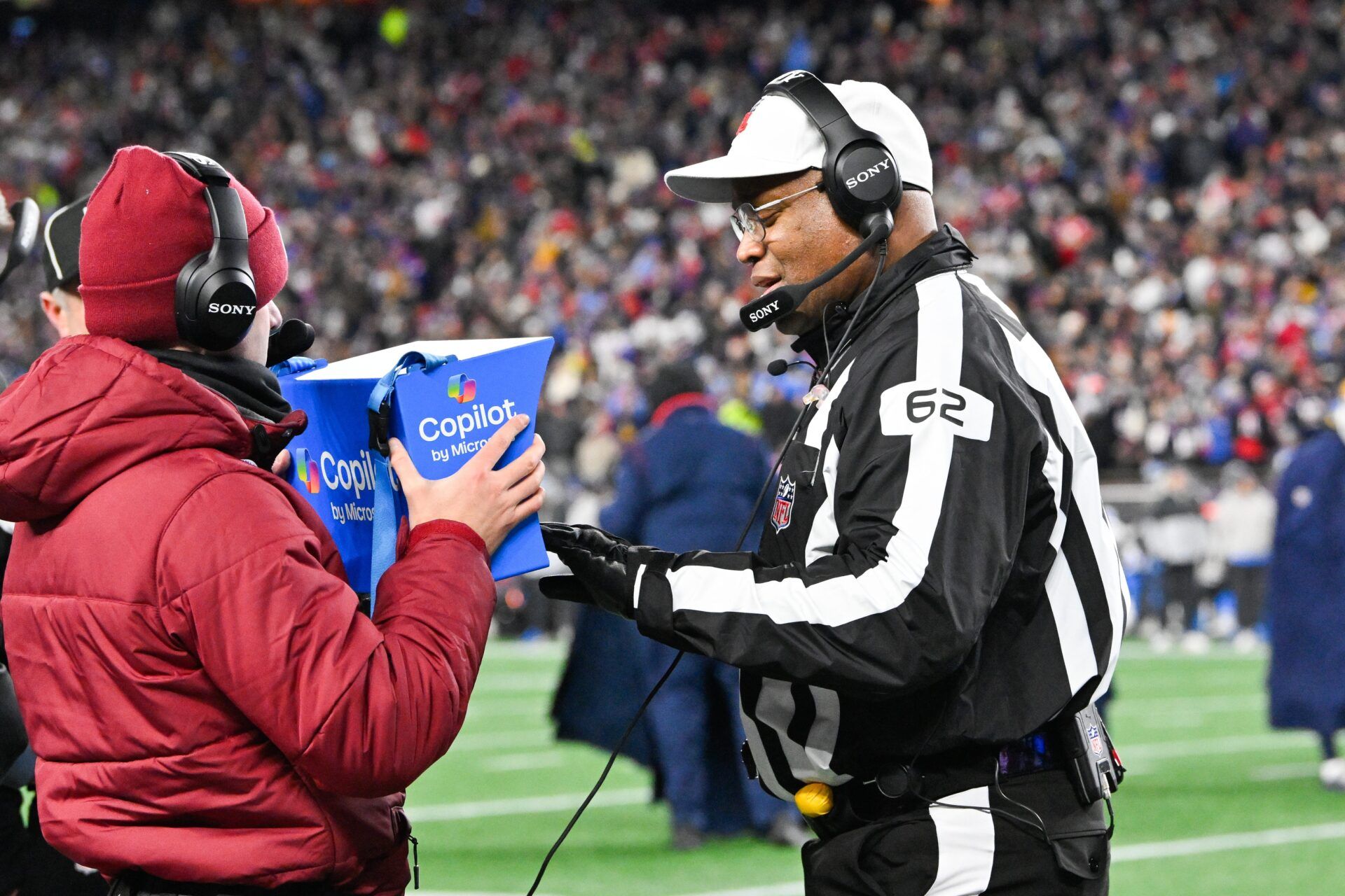 Referee Ron Torbert (62) reviews a play during the second quarter between the New England Patriots and the Los Angeles Chargers in an AFC Wild Card Round game at Gillette Stadium.