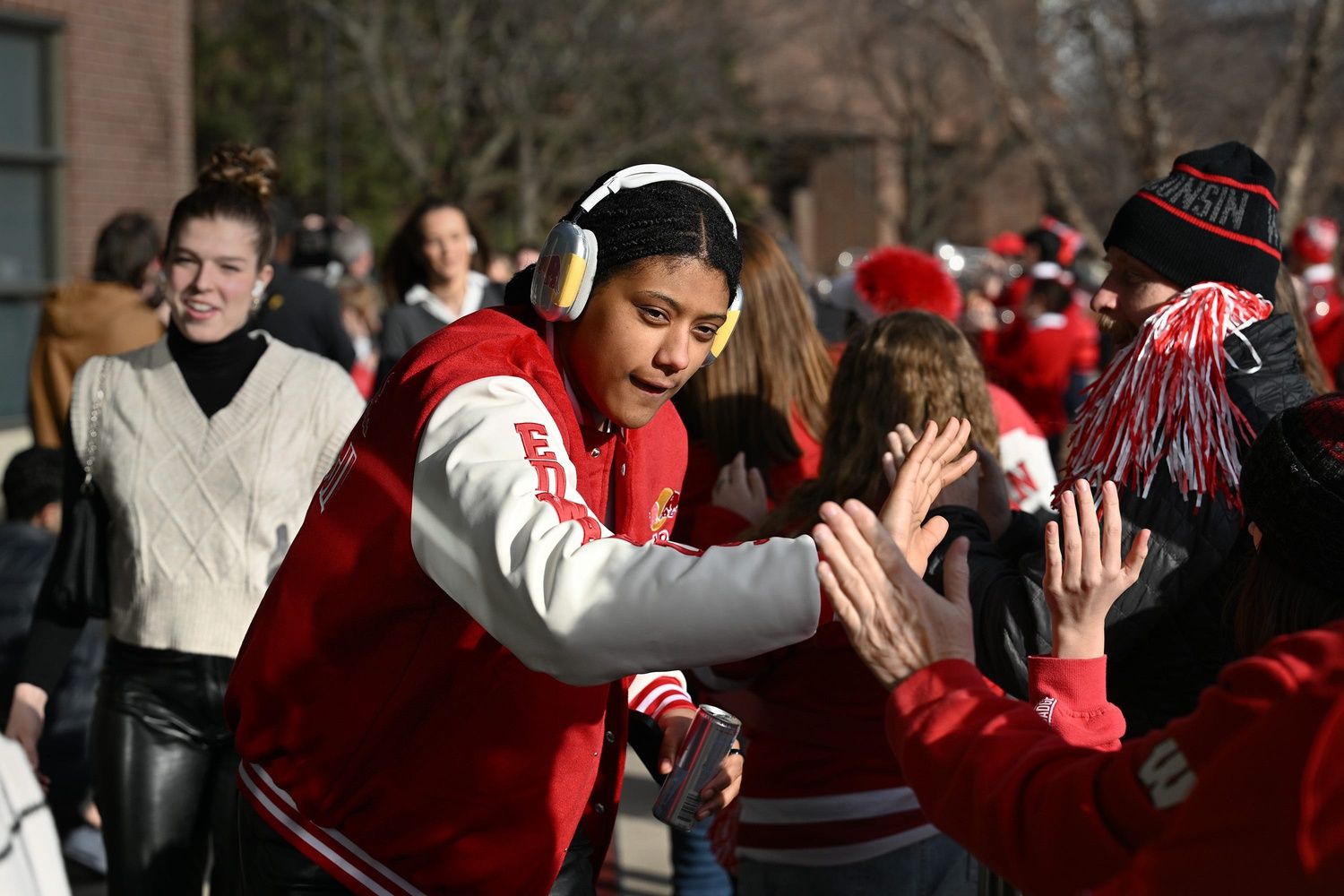 Wisconsin Badgers junior forward Laila Edwards high-fives a fan after arriving for a NCAA women's Frozen Four semifinal hockey game Friday, March 21, 2024, at Ridder Arena in Minneapolis, Minnesota.