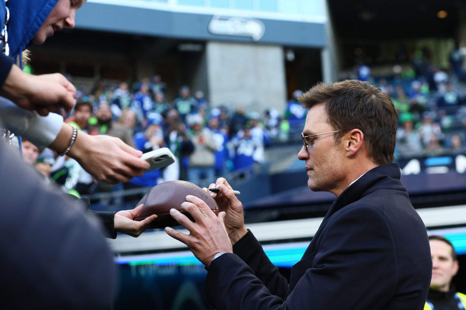 Tom Brady signs autographs before the 2026 NFC Championship Game between the Seattle Seahawks and the Los Angeles Rams at Lumen Field.
