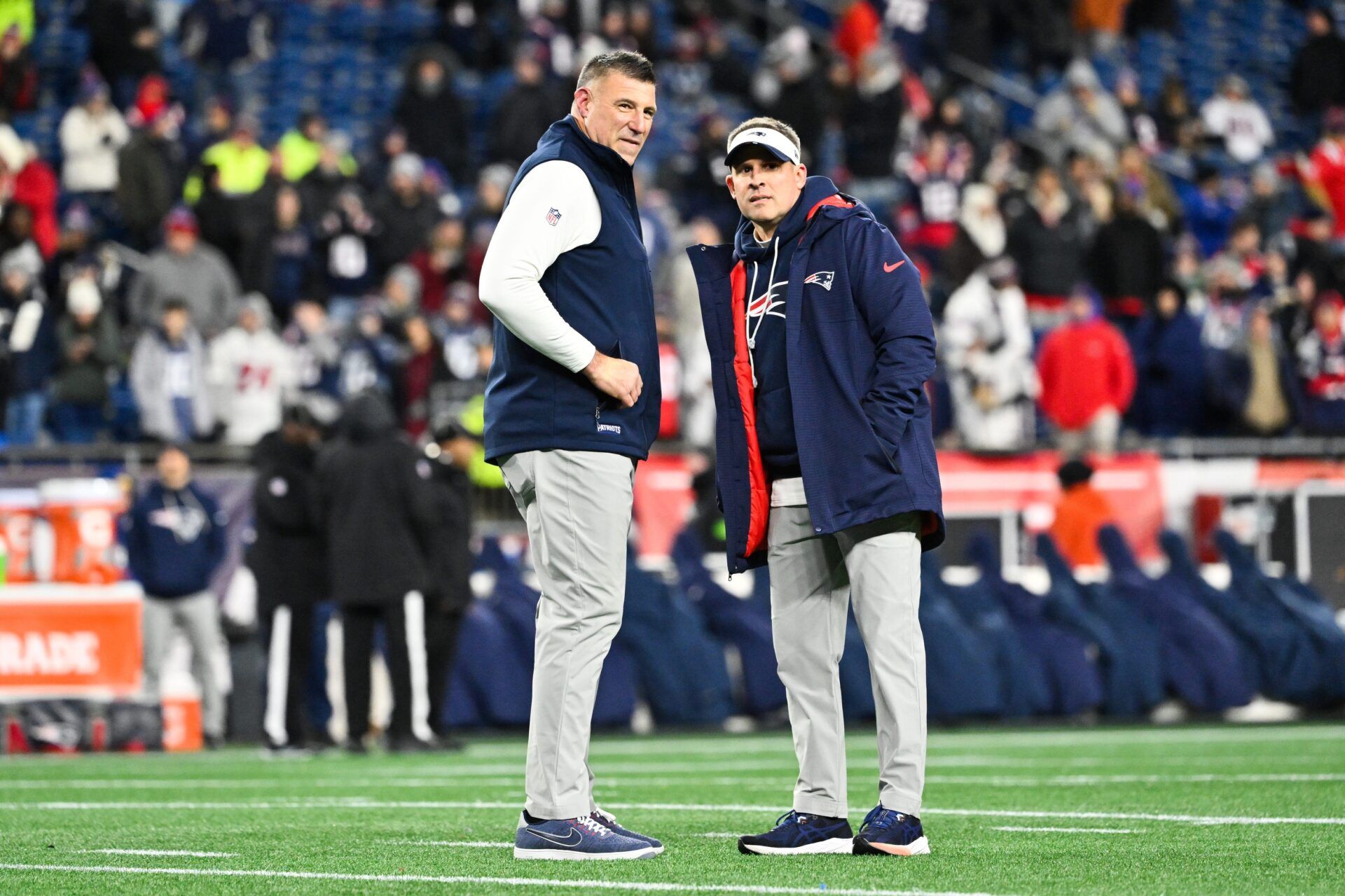 New England Patriots head coach Mike Vrabel and New England Patriots offensive coordinator Josh McDaniels look on before the game against the Los Angeles Chargers in an AFC Wild Card Round game at Gillette Stadium.