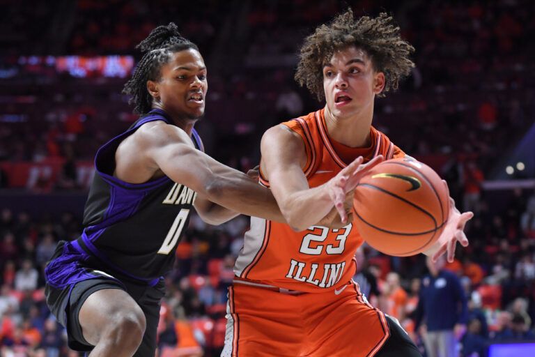 Washington Huskies guard Quimari Peterson (0) tries to knock the ball away from Illinois Fighting Illini guard Keaton Wagler (23) during the second half at State Farm Center.