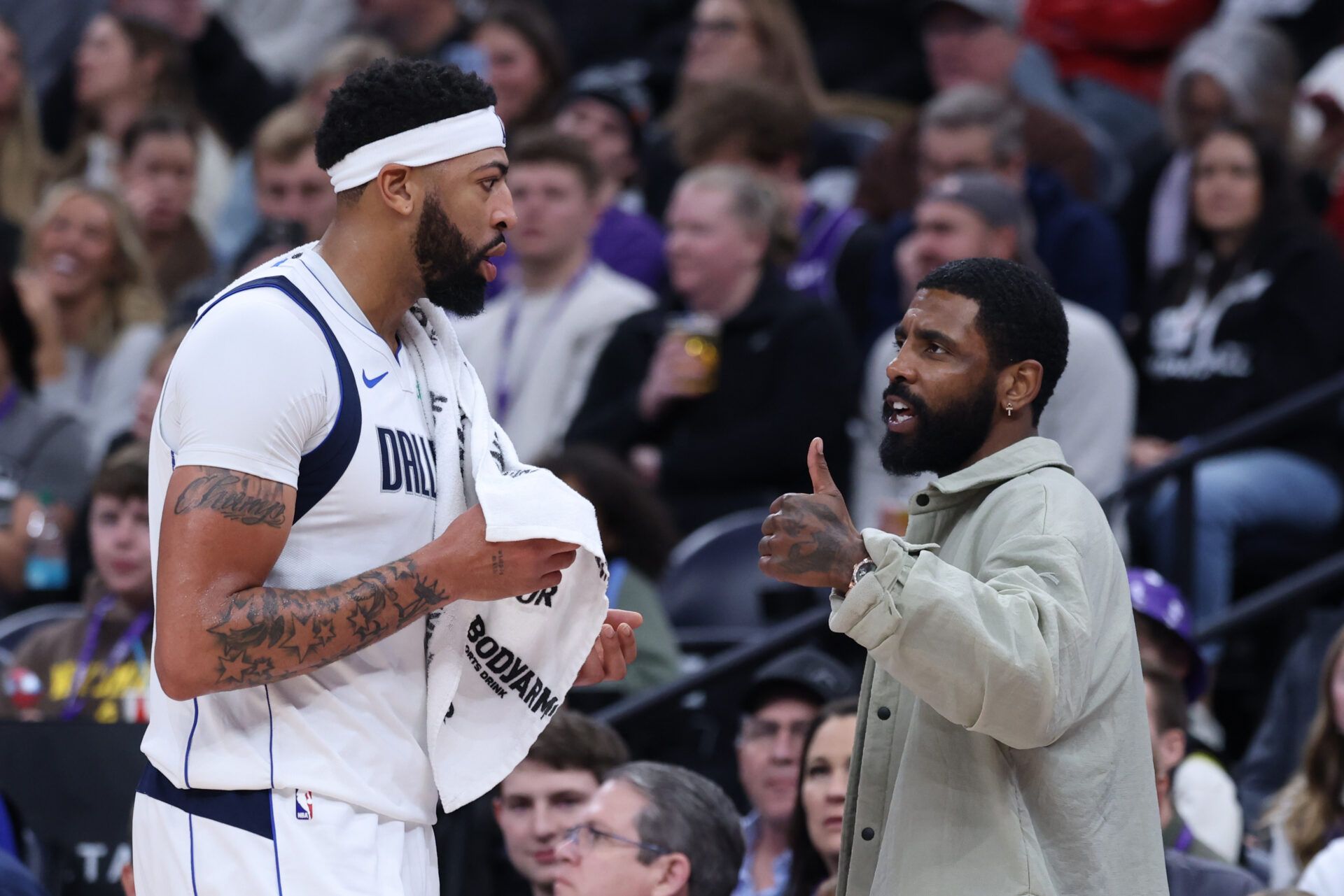 Dallas Mavericks forward Anthony Davis (l3) and guard Kyrie Irving (right) speak during a second half break in action against the Utah Jazz at Delta Center.