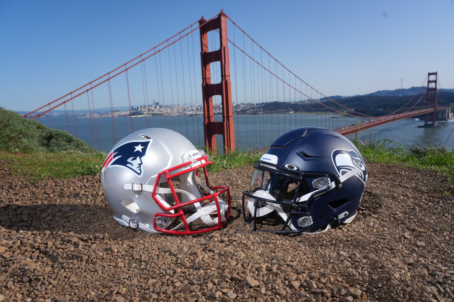 New England Patriots and Seattle Seahawks helmets with the Golden Gate bridge as a backdrop.