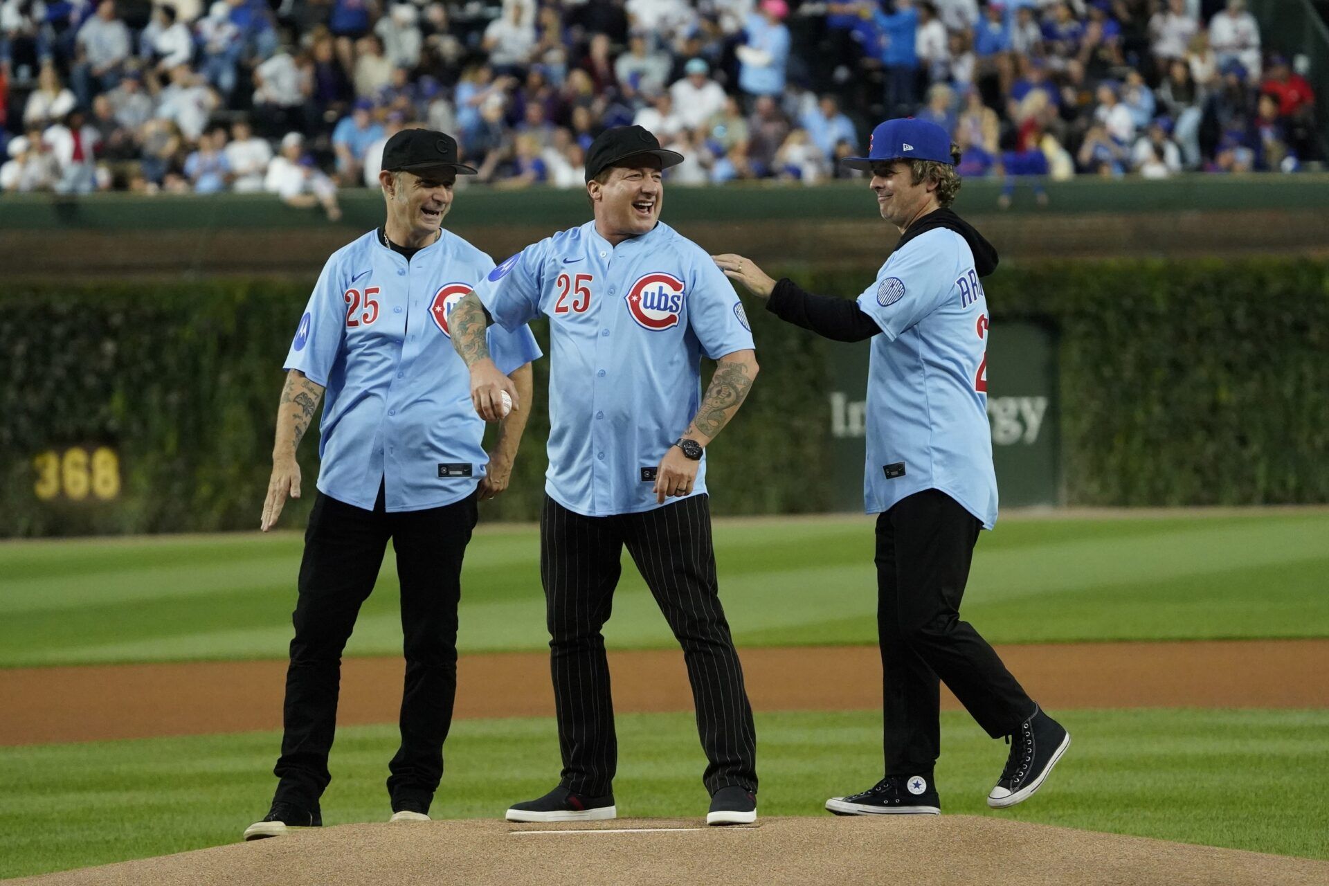 Rock and roll band Green Day throws out a ceremonial first pitch before a game between the Chicago Cubs and New York Mets at Wrigley Field.