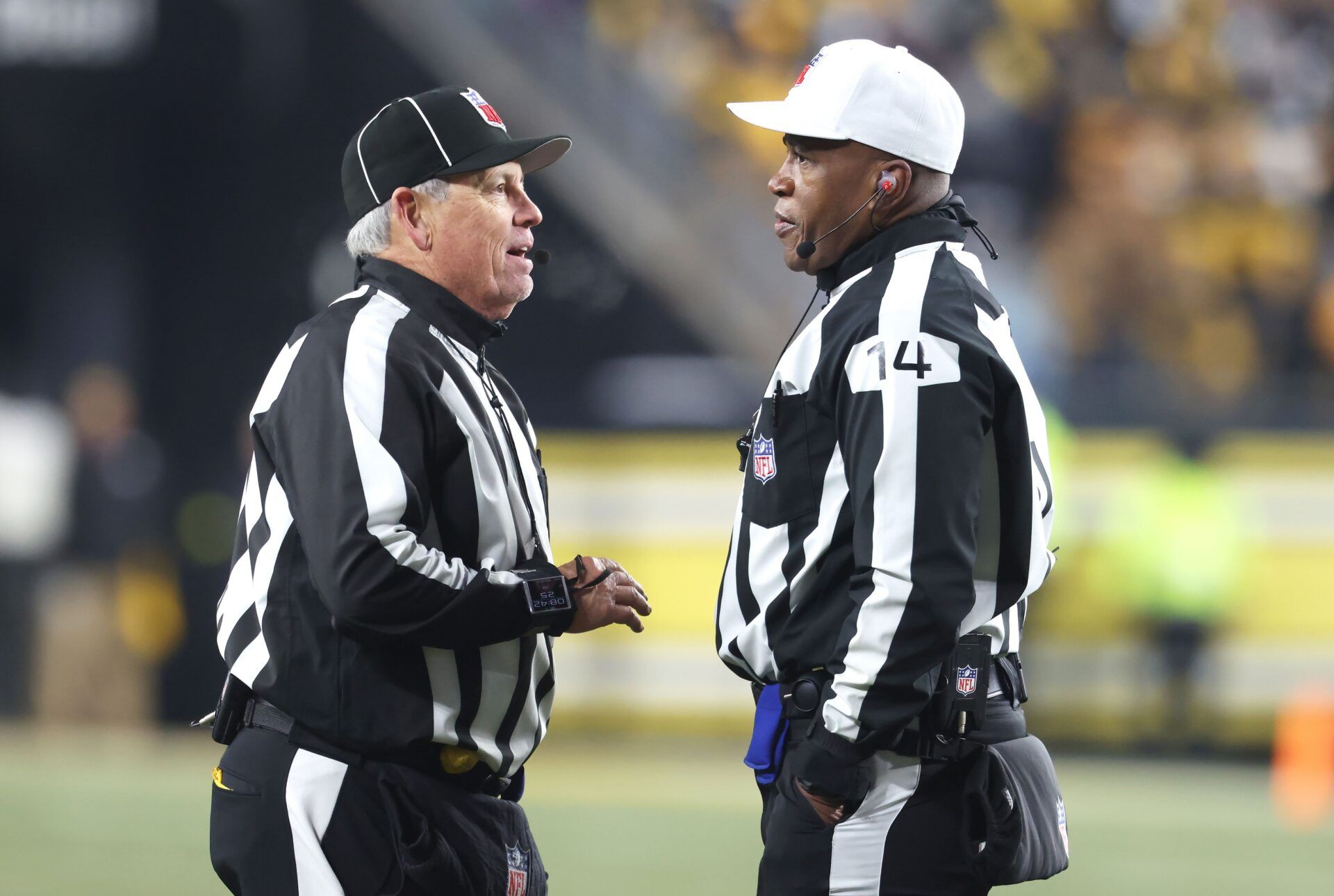 NFL line judge Jeff Seeman (left) and referee Shawn Smith (14) discuss a call during the fourth quarter between the Baltimore Ravens and the Pittsburgh Steelers at Acrisure Stadium.