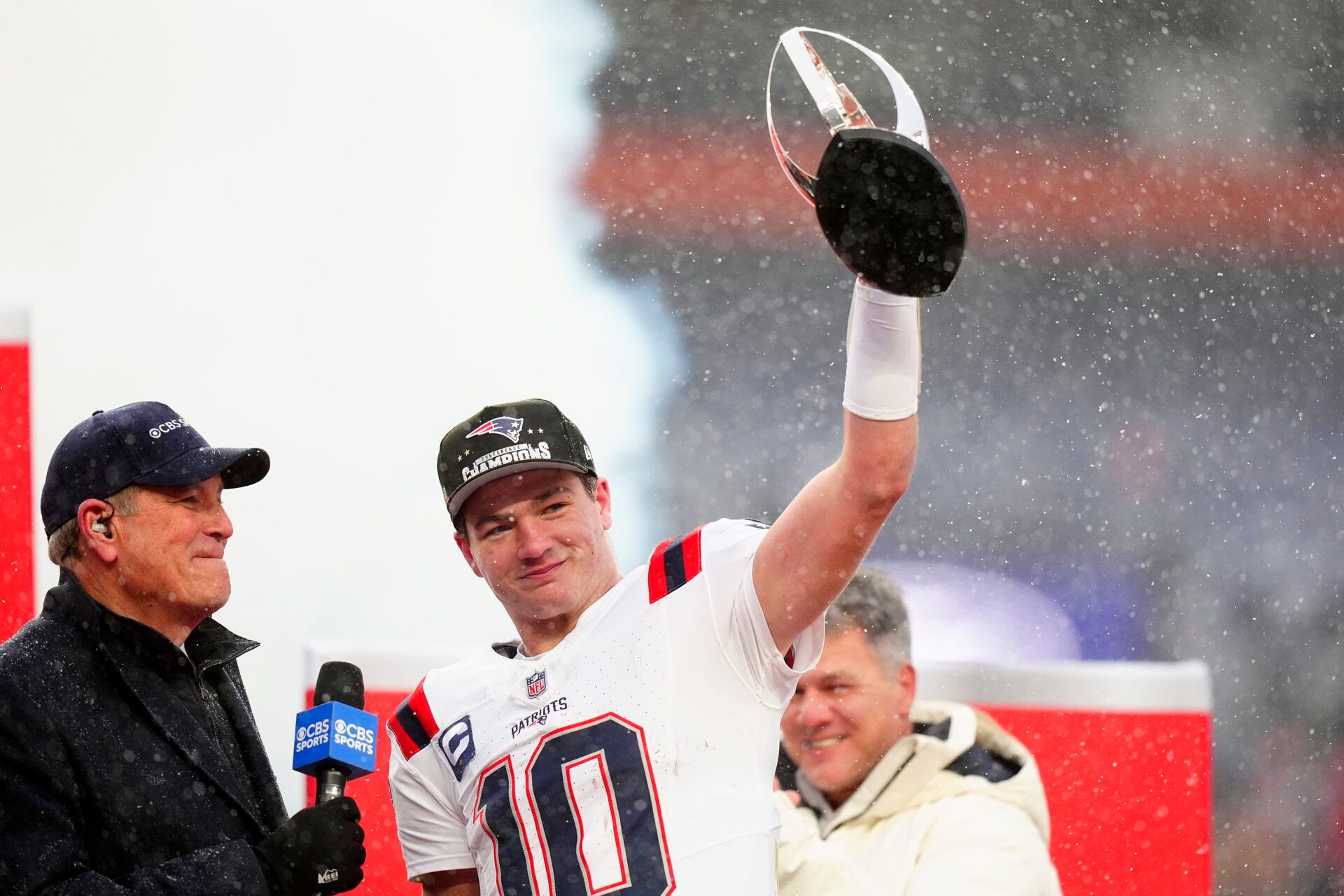 New England Patriots quarterback Drake Maye (10) holds the AFC Championship trophy while speaking to the media after defeating the Denver Broncos in the 2026 AFC Championship Game at Empower Field at Mile High.