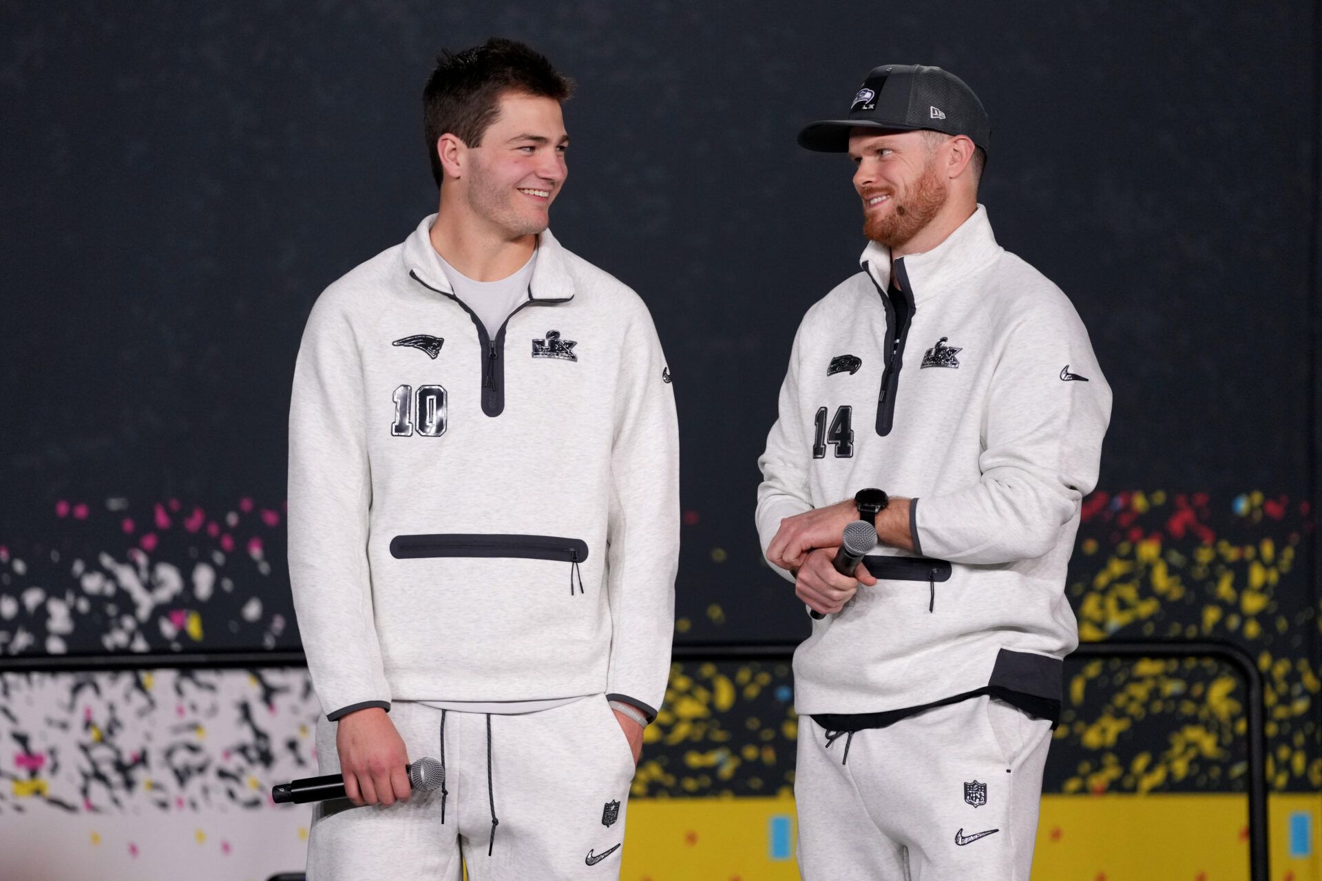 Seattle Seahawks quarterback Sam Darnold (14) and New England Patriots quarterback Drake Maye (10) look on during Opening Night for Super Bowl LX at San Jose Convention Center.