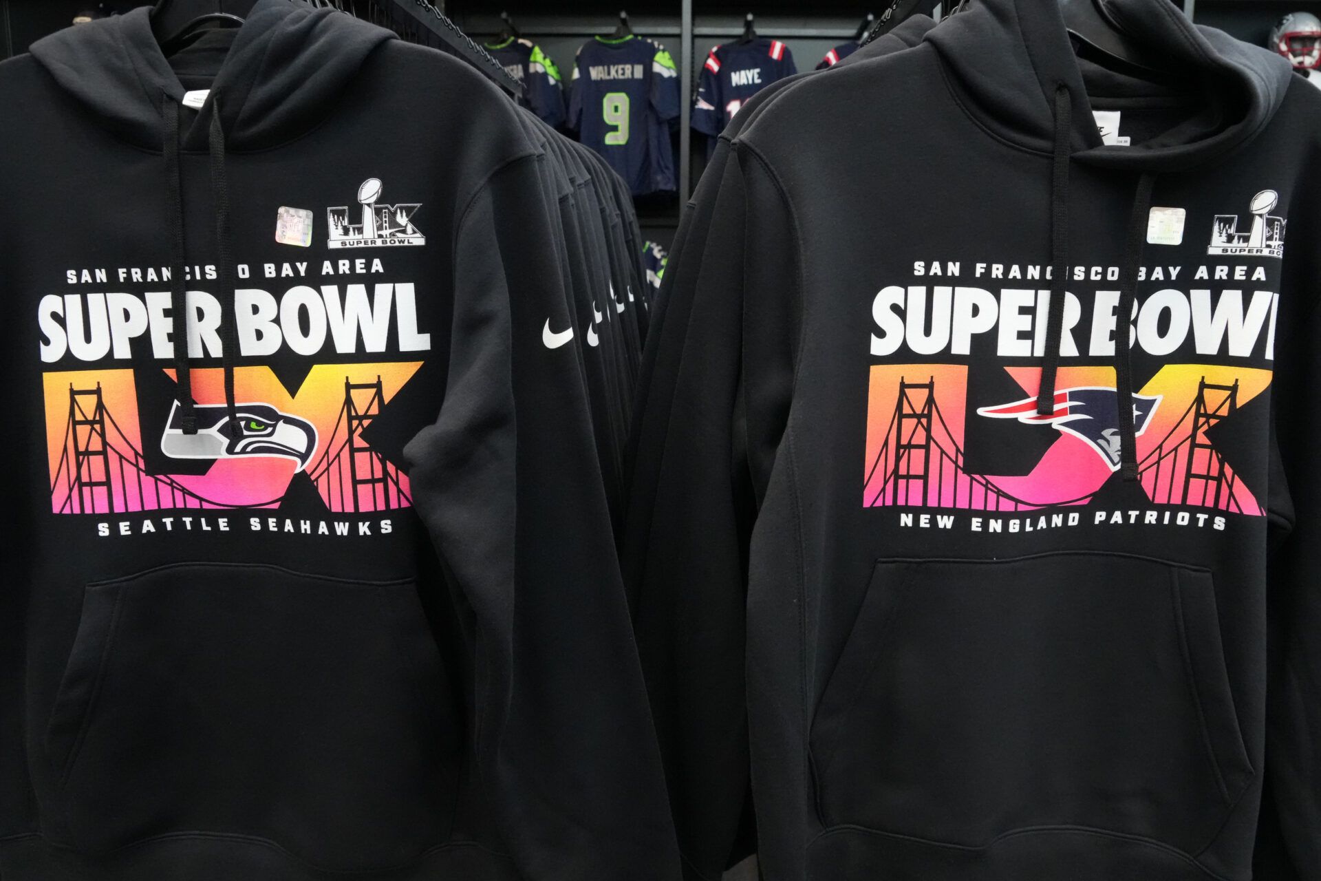 Nike brand Super Bowl 60 hoodies with the Seattle Seahawks and New England Patriots logos at the Super Bowl LX Experience NFL Shop at the Moscone Center.