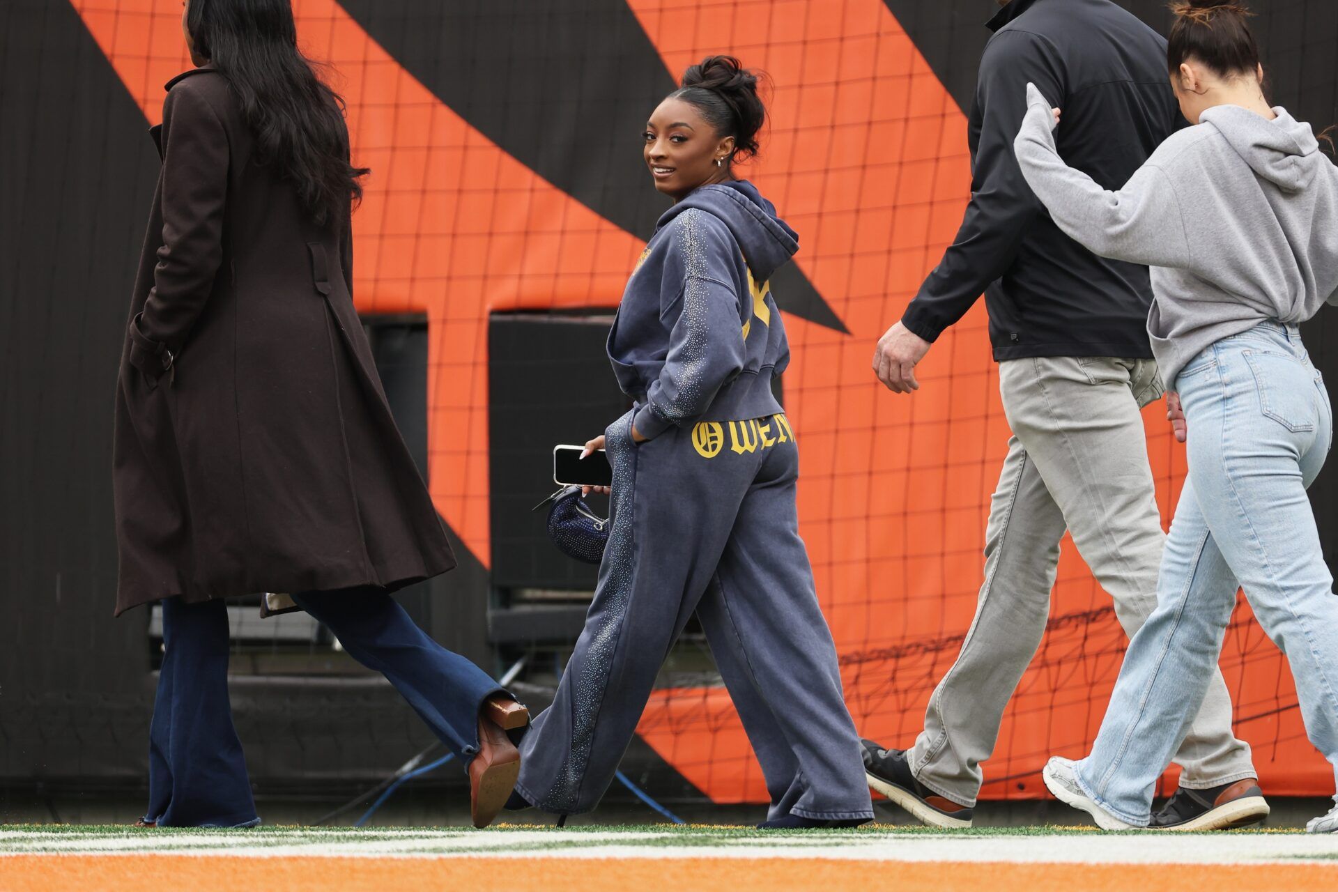 American gymnast Simone Biles walks on the field before the game between the Chicago Bears and the Cincinnati Bengals at Paycor Stadium.