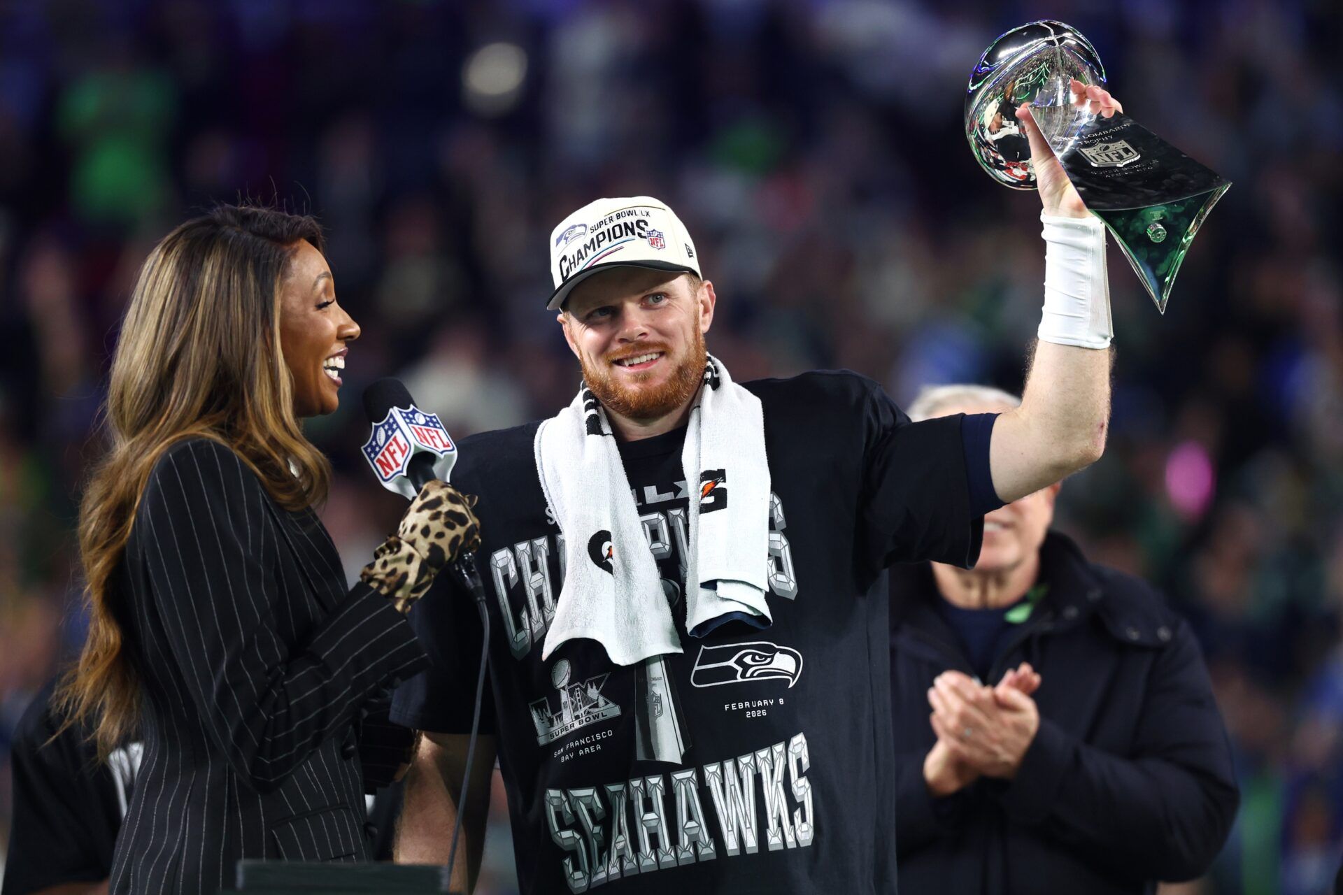 Seattle Seahawks quarterback Sam Darnold (14) celebrates with the Vince Lombardi trophy on the podium after defeating the New England Patriots in Super Bowl LX at Levi's Stadium.