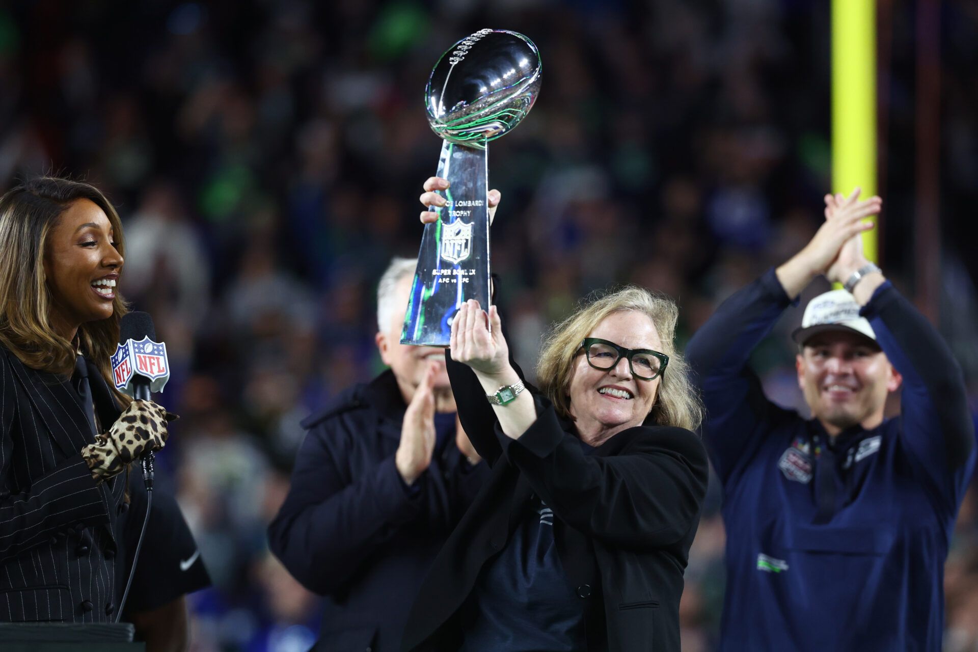 Seattle Seahawks chairman Jody Allen celebrates with the Vince Lombardi trophy on the podium after defeating the New England Patriots in Super Bowl LX at Levi's Stadium.