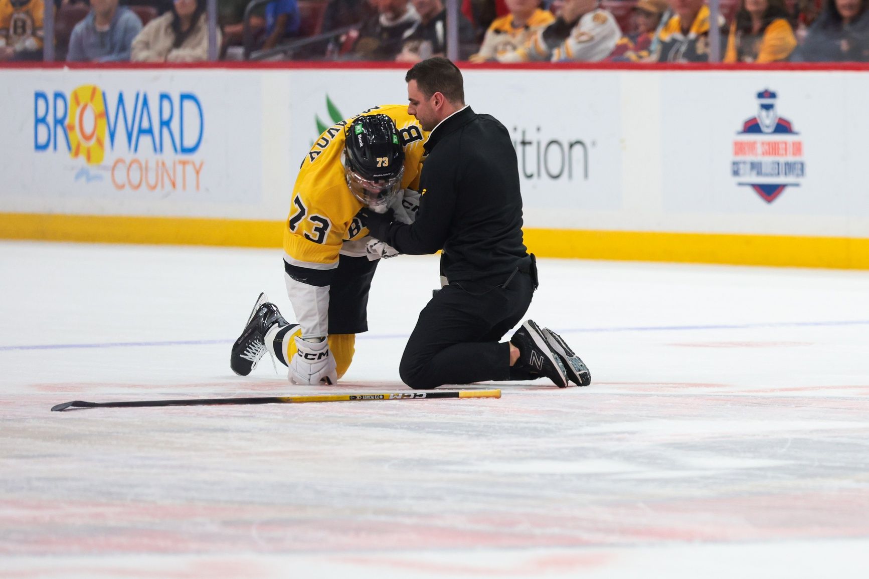 Boston Bruins defenseman Charlie McAvoy (73) is looked at by a trainer after an apparent injury against the Florida Panthers during the first period at Amerant Bank Arena.