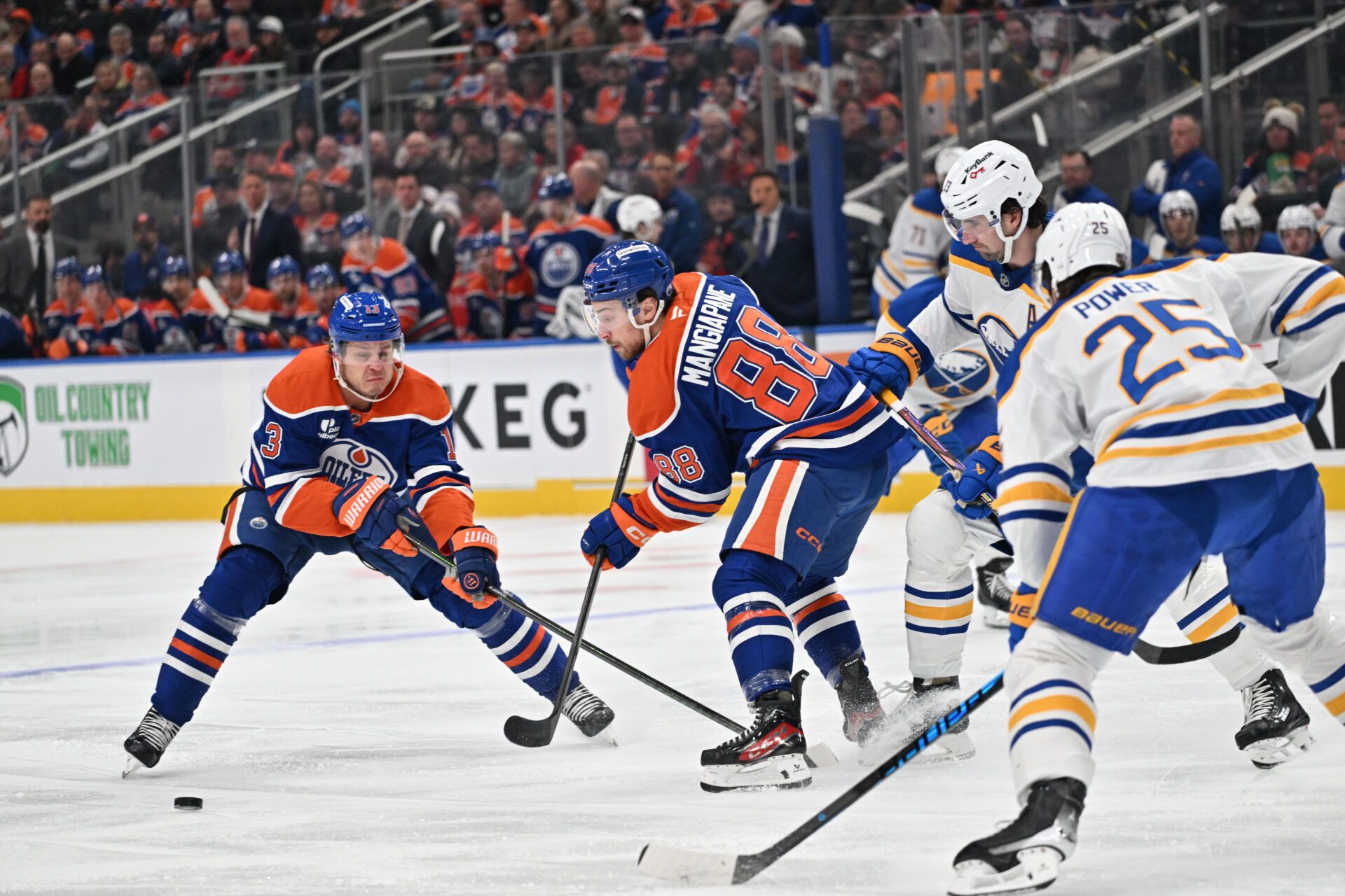 Edmonton Oilers center Mattias Janmark (13) and left winger Andrew Mangiapane (88) go for the puck with Buffalo Sabres defenseman Owen Power (25) during the first period at Rogers Place.