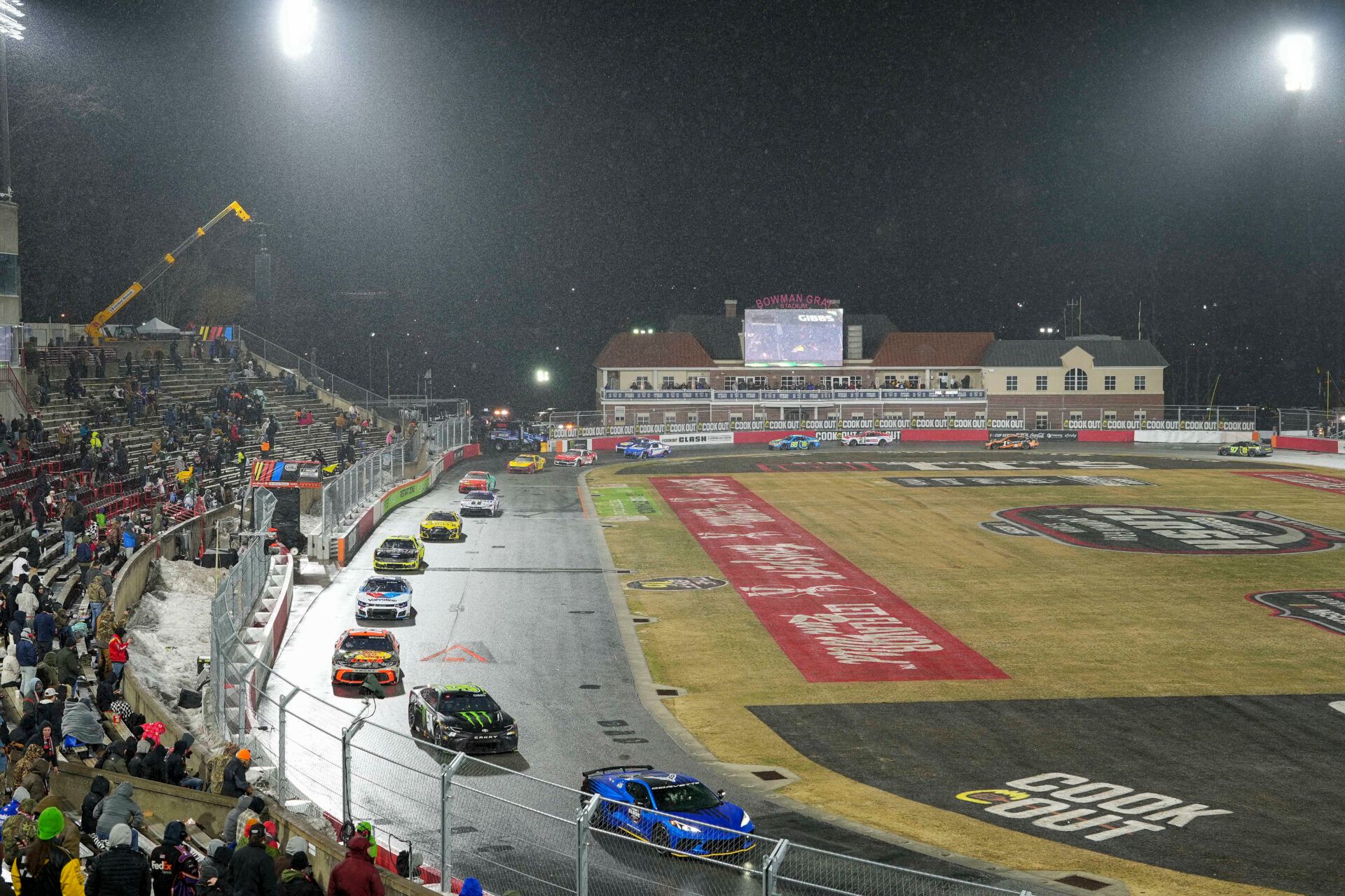 Cars carefully drive around the wet surface after sleet and rain coat the track during the Cook Out Clash at Bowman Gray Stadium.