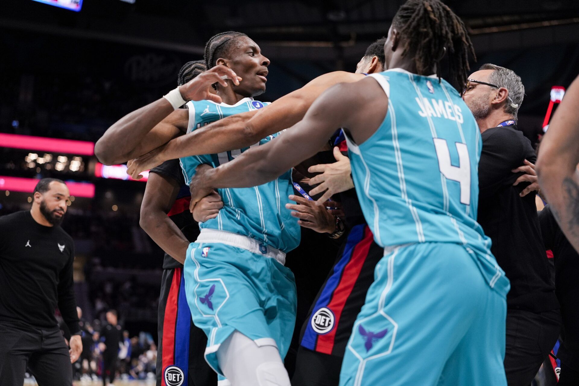 Charlotte Hornets forward Moussa Diabaté (14) is held back by guard Sion James (4) engaging with Detroit Pistons forward Tobias Harris (12) during the second half at Spectrum Center.