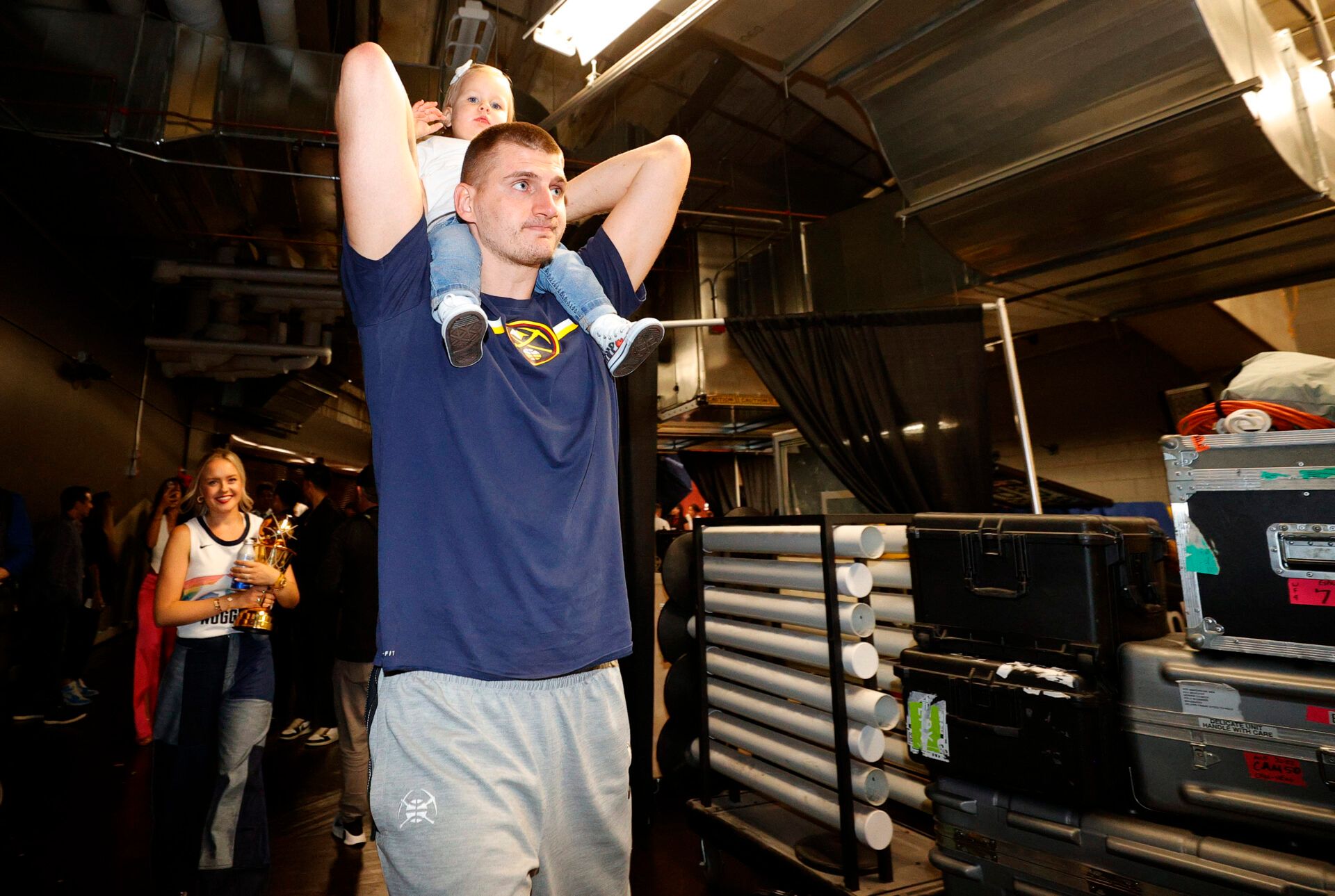 Denver Nuggets center Nikola Jokic (15) carries his daughter Ognjena in front of his wife with the Bill Russell NBA Finals MVP trophy after the Nuggets won the NBA championship by defeating the Miami Heat in game five of the 2023 NBA Finals at Ball Arena.