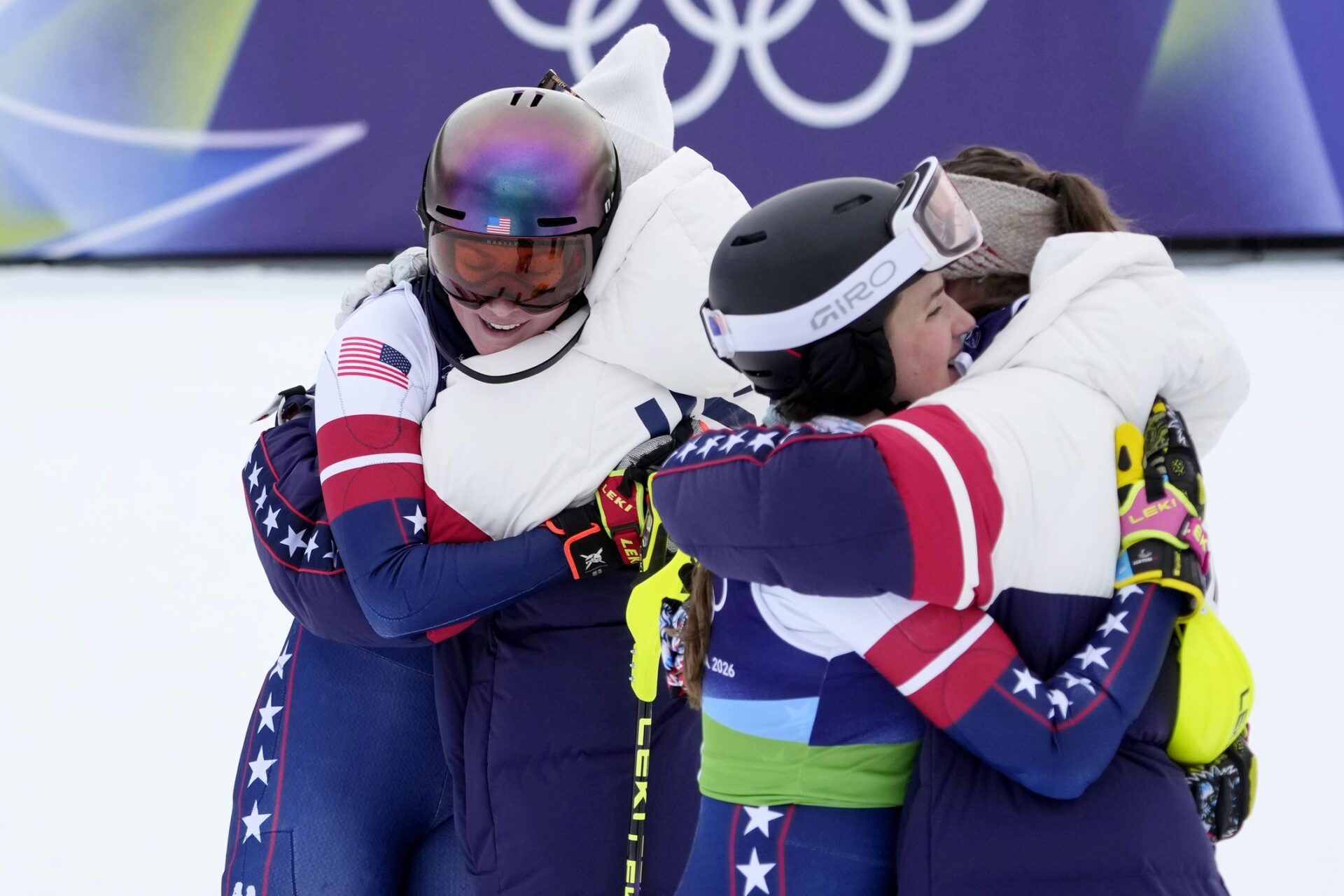 Mikaela Shiffrin, Breezy Johnson, Paula Moltzan, and Jacqueline Wiles of the United States hug after alpine skiing women's team combined during the Milano Cortina 2026 Olympic Winter Games at Tofane Alpine Skiing Centre.