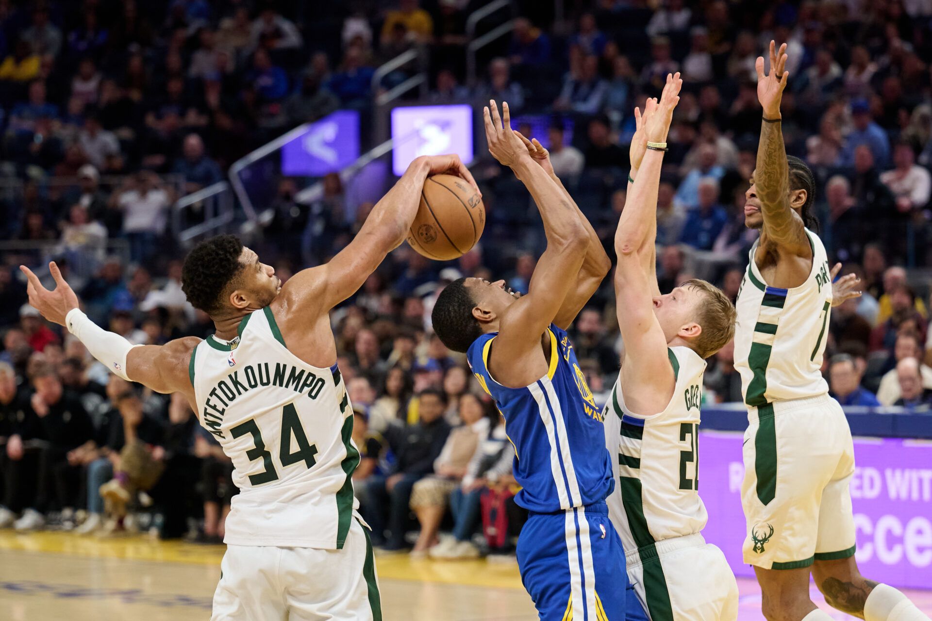 Milwaukee Bucks forward Giannis Antetokounmpo (34) blocks a shot and guards AJ Green (20) and Kevin Porter Jr. (7) defend against Golden State Warriors guard De'Anthony Melton (8) during the fourth quarter at Chase Center.