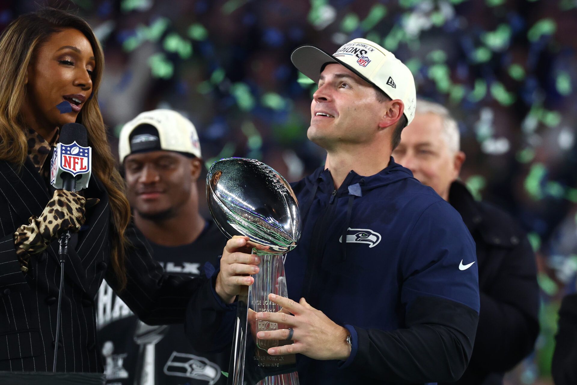 Seattle Seahawks head coach Mike MacDonald celebrates with the Vince Lombardi trophy on the podium after defeating the New England Patriots in Super Bowl LX at Levi's Stadium.