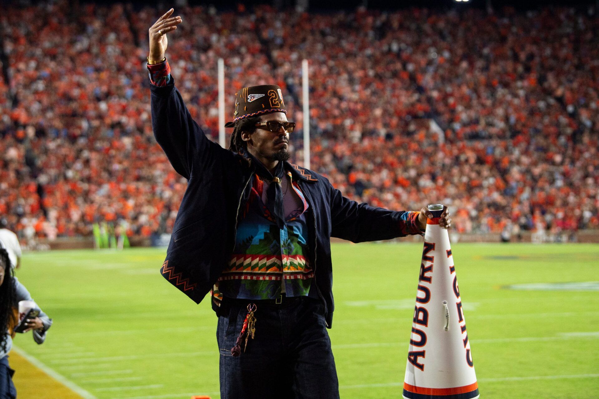 Former Auburn quarterback Cam Newton cheers on his team from the sideline as Auburn Tigers take on Georgia Bulldogs at Jordan-Hare Stadium in Auburn, Ala. on Saturday, Oct. 11, 2025. Auburn Tigers lead Georgia Bulldogs 10-3 at halftime.