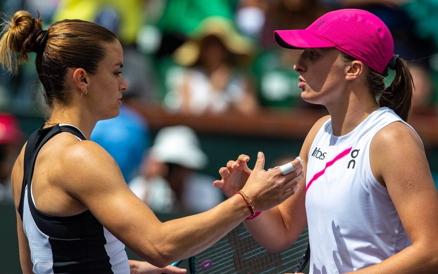 Iga Swiatek (right) shakes hands with Maria Sakkari after winning their WTA final match at the BNP Paribas Open in Indian Wells, Calif., Sunday, March 17, 2024.