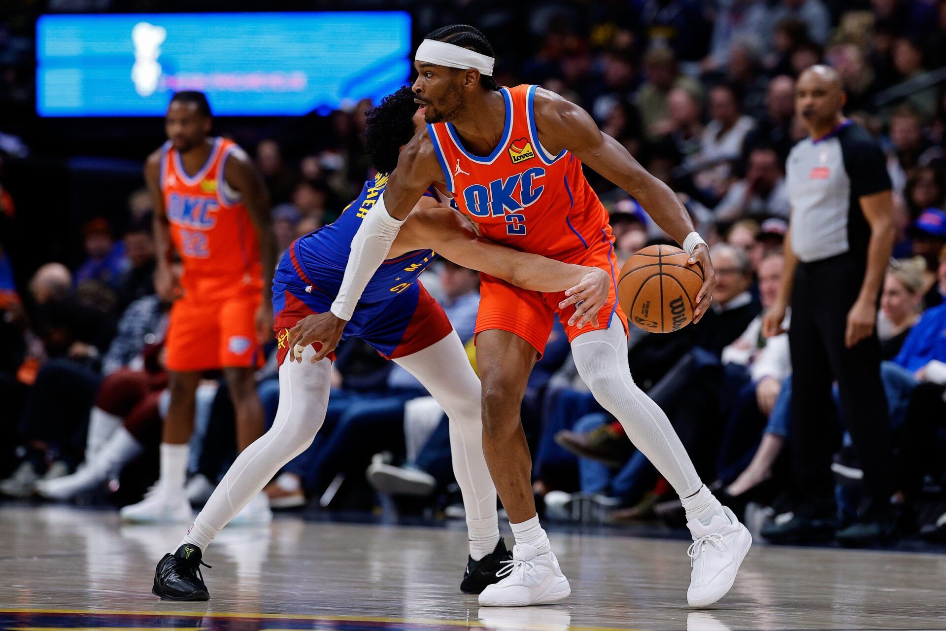 Oklahoma City Thunder guard Shai Gilgeous-Alexander (2) controls the ball under pressure from Denver Nuggets guard Julian Strawther (3) in the fourth quarter at Ball Arena.