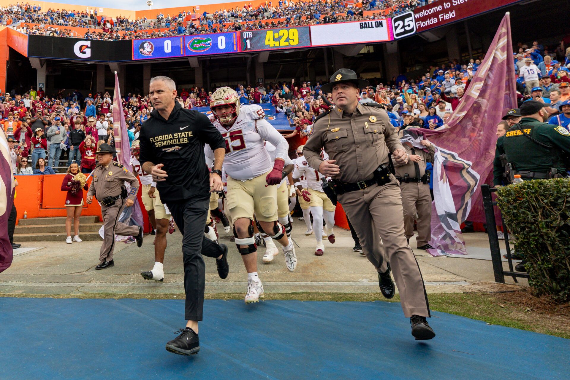 Florida State Seminoles head coach Mike Norvell leads his team onto the field before the game against the Florida Gators at Ben Hill Griffin Stadium.