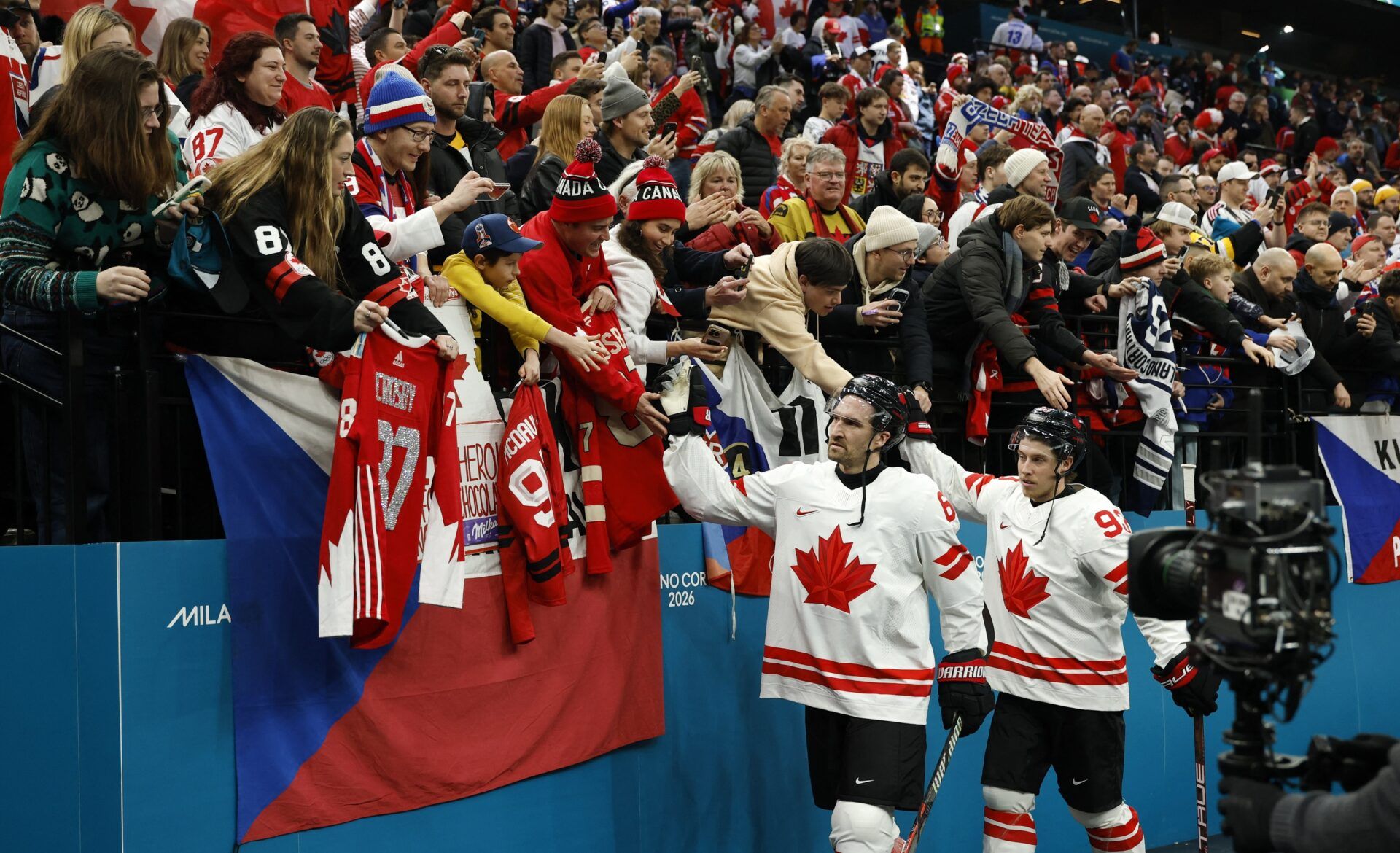 Mitch Marner and Mark Stone of Canada celebrate with fans after the match against Czechia  in a men's ice hockey group A match during the Milano Cortina 2026 Olympic Winter Games at Milano Santagiulia Ice Hockey Arena.