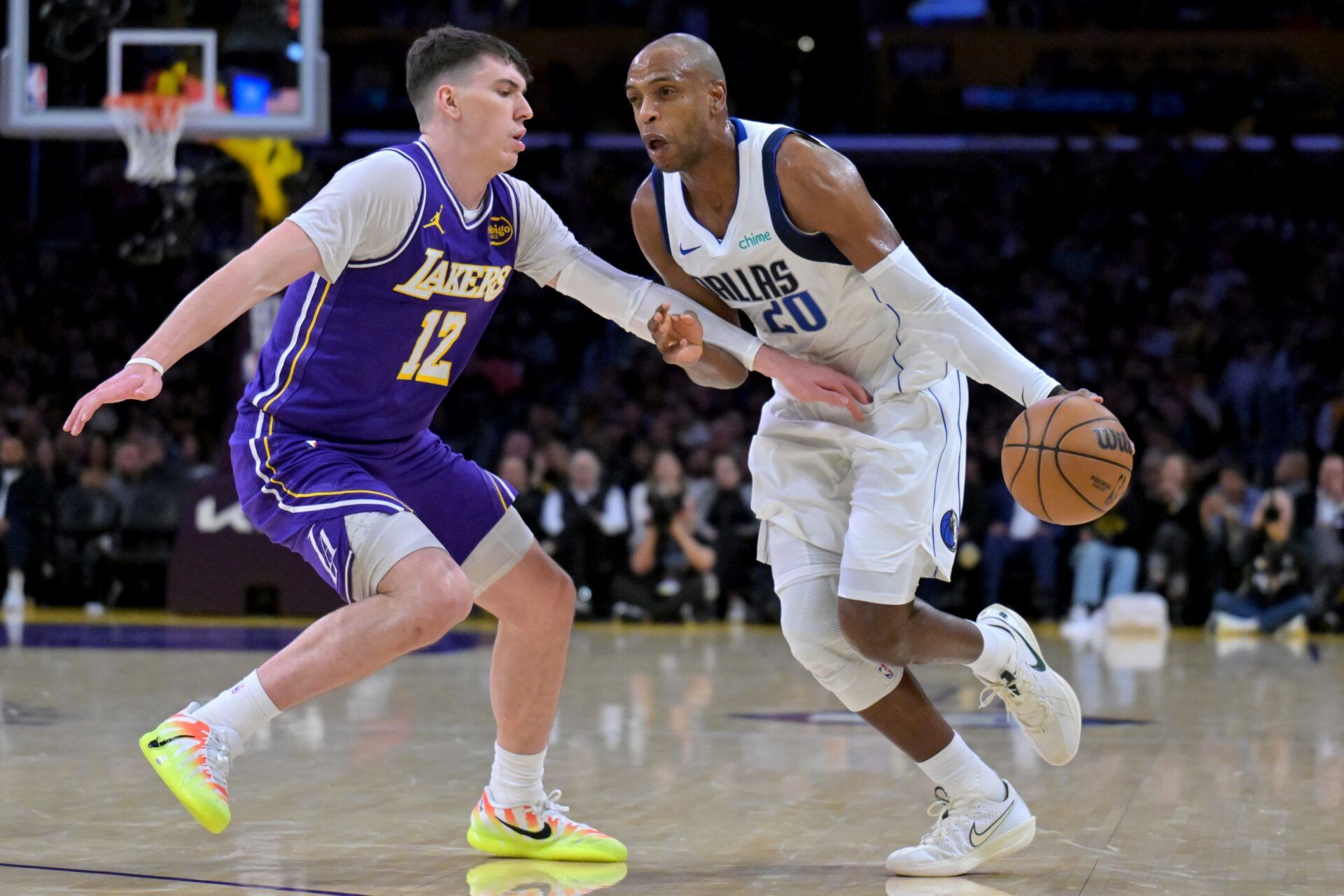 Los Angeles Lakers forward Jake LaRavia (12) defends Dallas Mavericks forward Khris Middleton (20) in the second half at Crypto.com Arena.