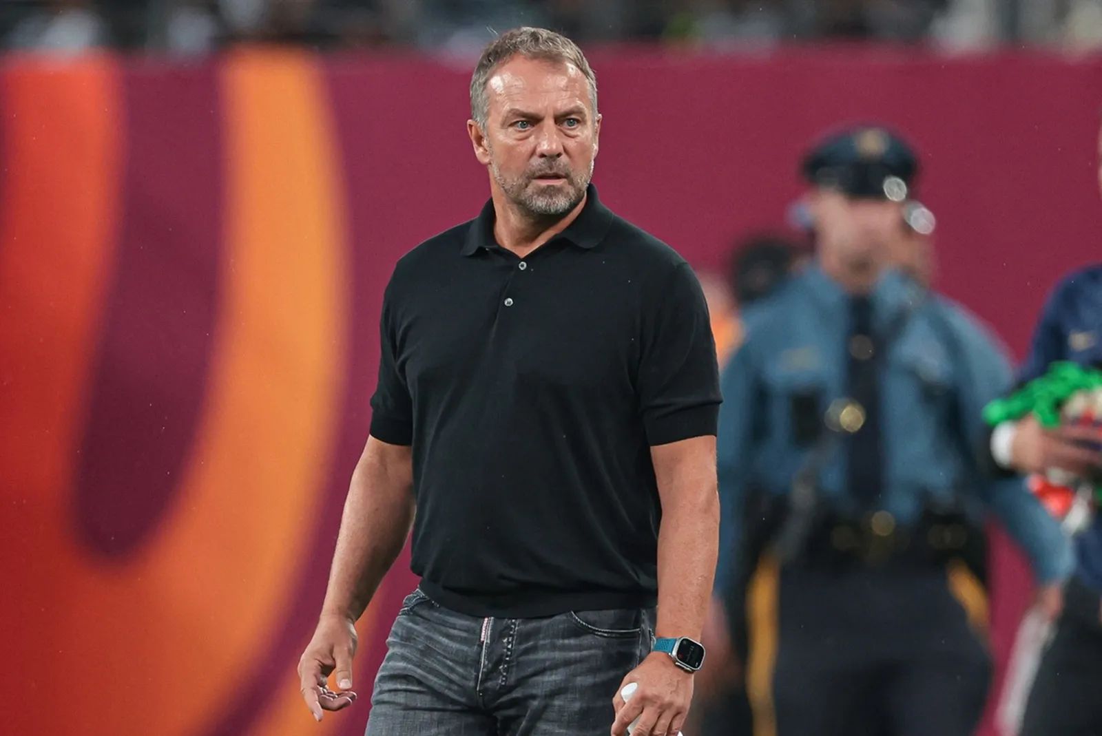 Barcelona head coach Hansi Flick walks off the pitch during a weather delay during an international friendly against Real Madrid at MetLife Stadium.