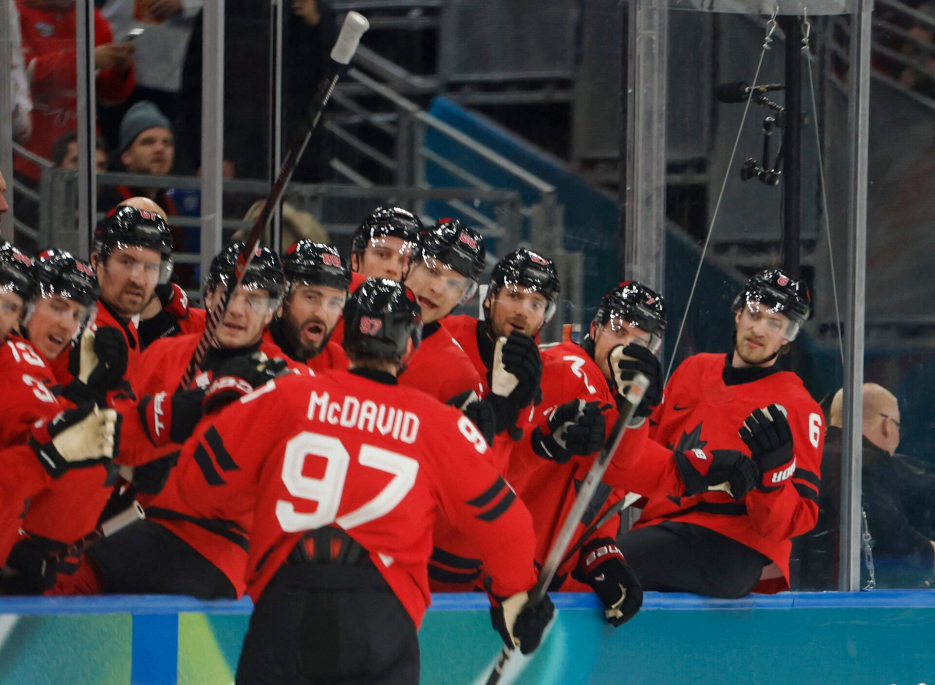 Connor McDavid of Canada celebrates with teammates after scoring their first goal against Switzerland in men's ice hockey group A play during the Milano Cortina 2026 Olympic Winter Games at Milano Santagiulia Ice Hockey Arena.