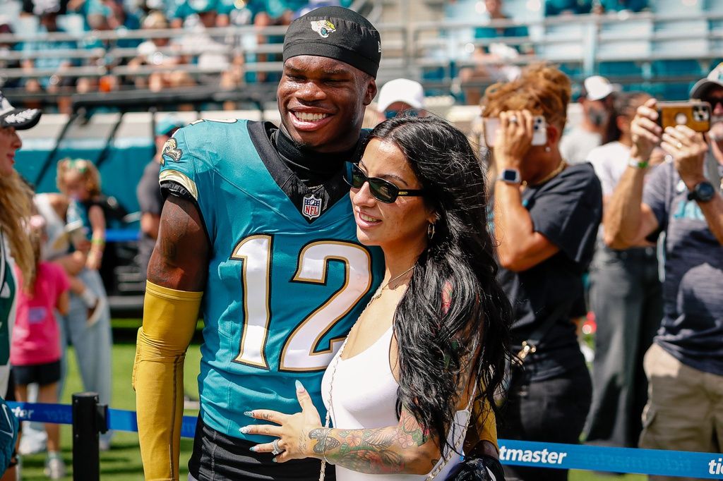 Jacksonville Jaguars player Travis Hunter (12) with his wife during pregame against the Houston Texans at EverBank Stadium.