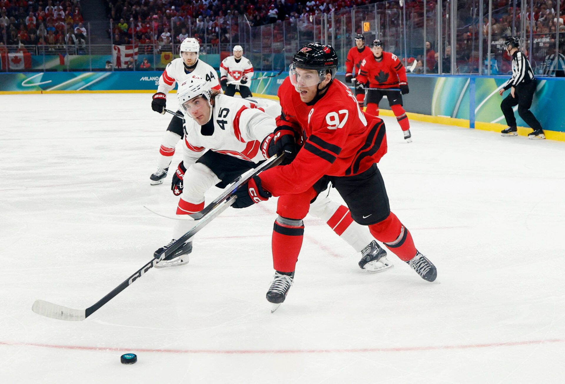Connor McDavid of Canada in action with Michael Fora of Switzerland in men's ice hockey group A play during the Milano Cortina 2026 Olympic Winter Games at Milano Santagiulia Ice Hockey Arena.